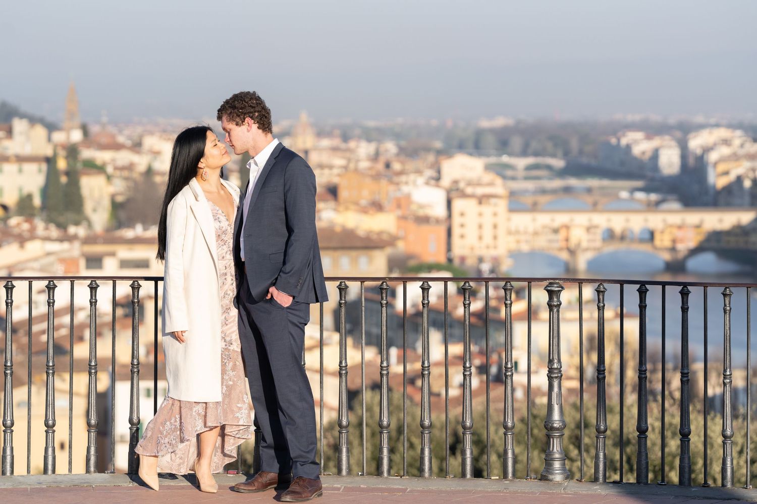 A couple shares a romantic moment overlooking the scenic cityscape of Prague from a hilltop viewpoint.