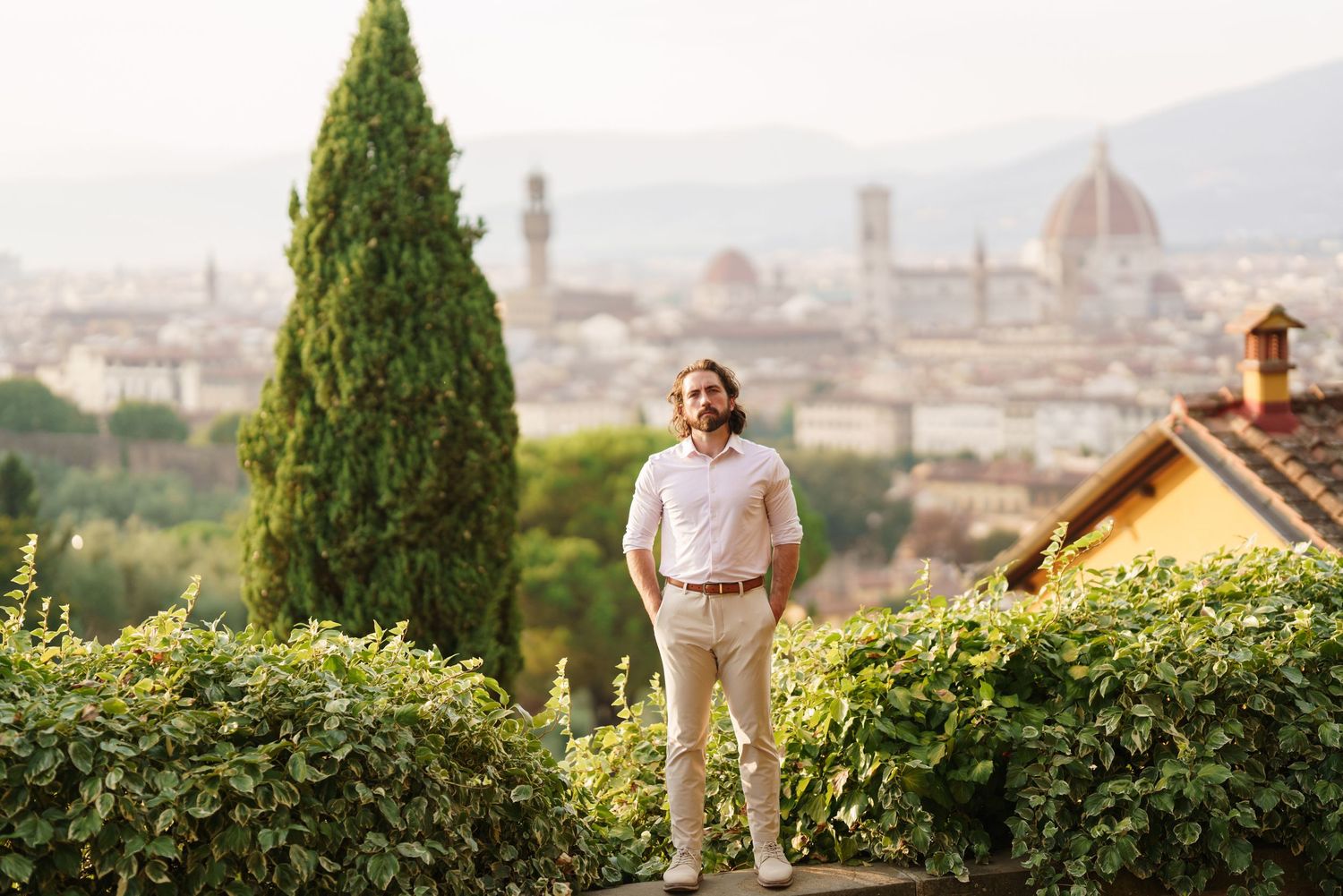 Scenic panoramic view of Florence Italy with cypress trees and the Duomo cathedral dome in the background.