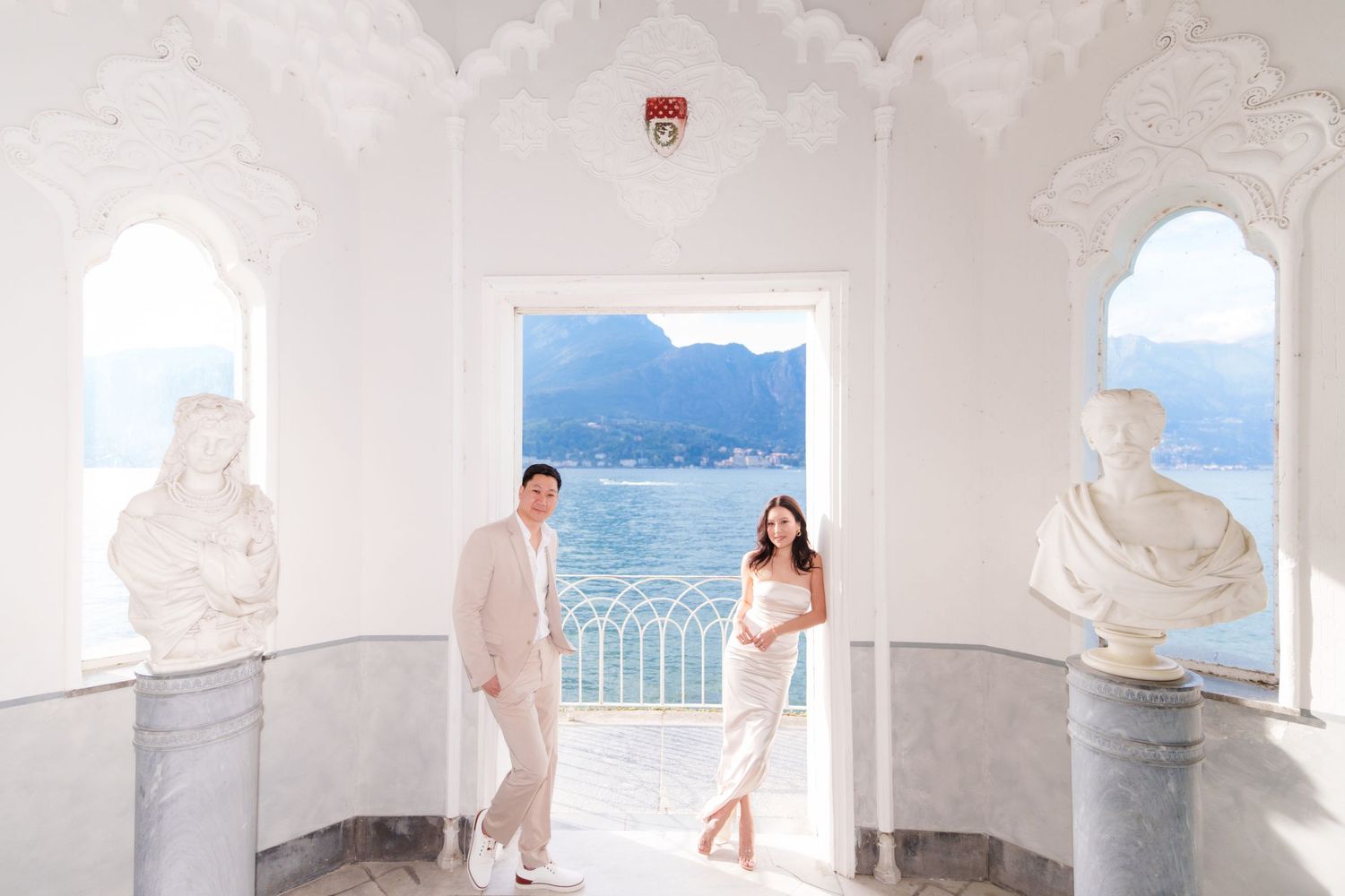 A series of white arched Mediterranean balconies overlooking a coastal view with blue ocean waters.