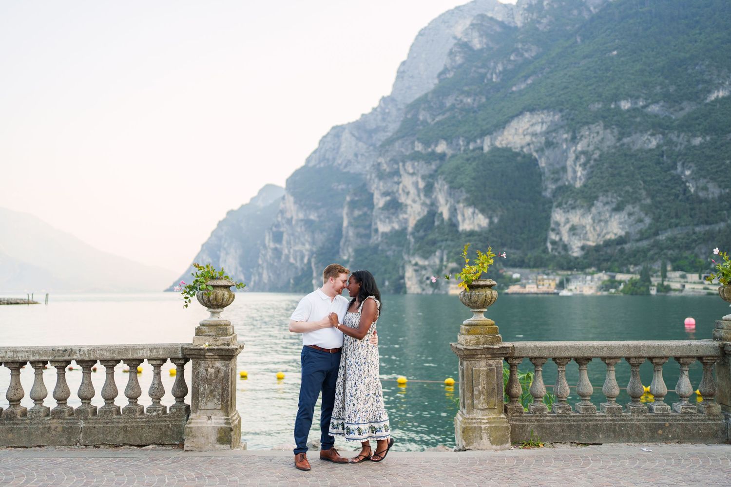 Engaged couple embracing beside Lake Garda during their Riva del Garda proposal session