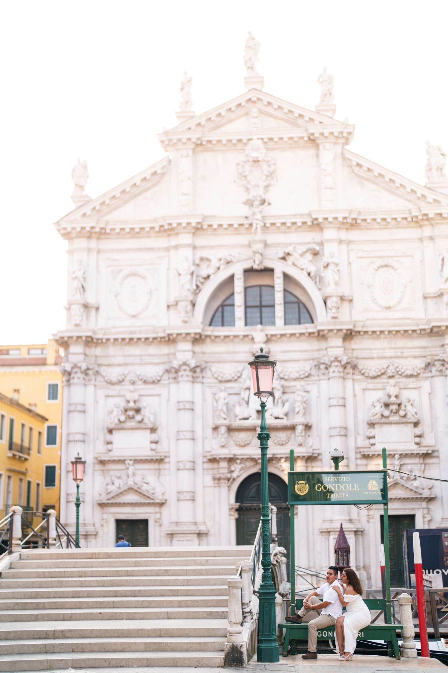 Ornate white baroque church facade with grand stone steps and decorative architectural details in Venice, Italy.