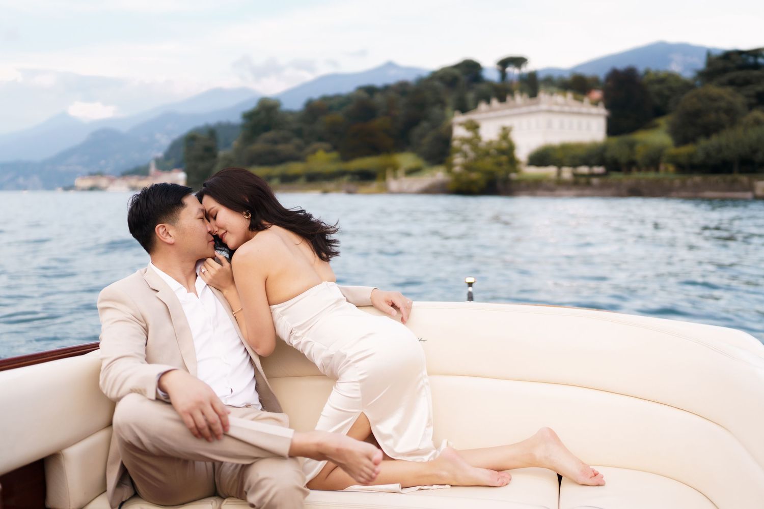 A romantic couple shares intimate moments on a luxury yacht while sailing along a scenic coastline.