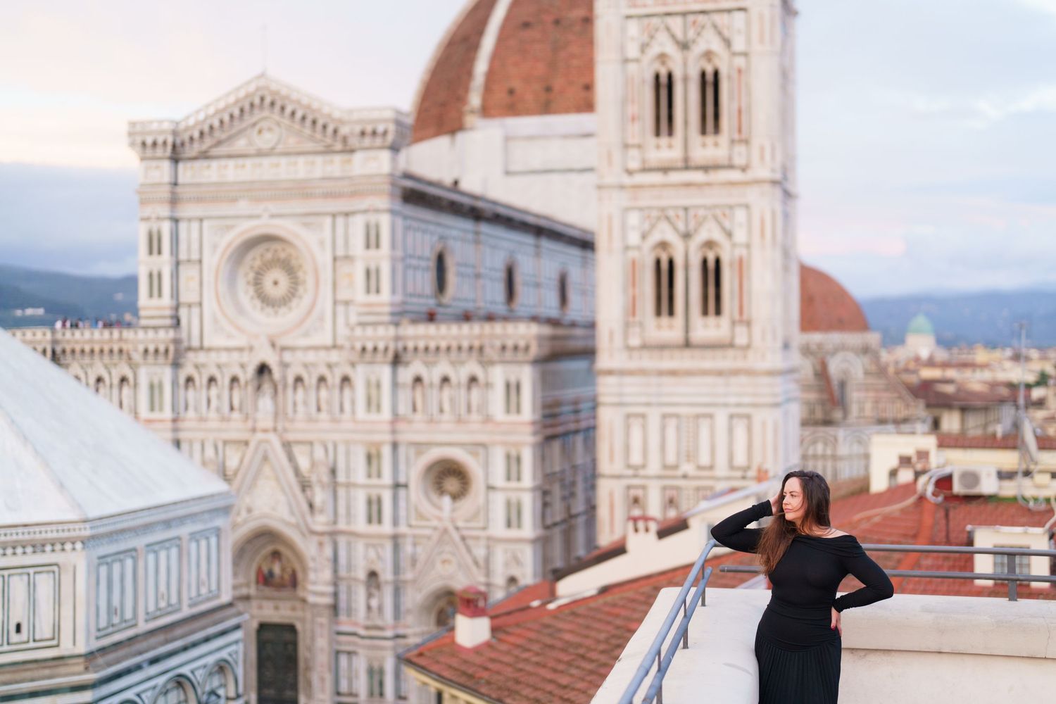 Panoramic view of Florence Cathedral and Giotto's Bell Tower with red-tiled rooftops in Italy.