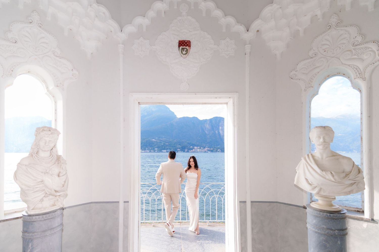 A series of white interior spaces with windows overlooking a scenic mountain and water view.