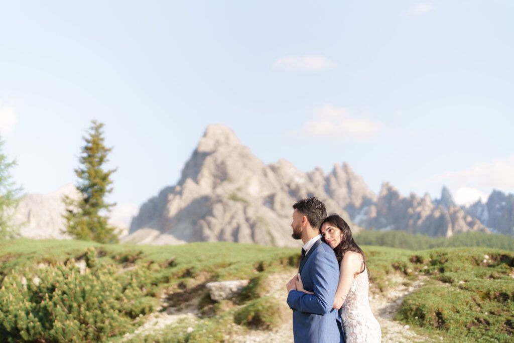 A romantic mountain wedding photoshoot with dramatic Dolomite peaks and green meadows.