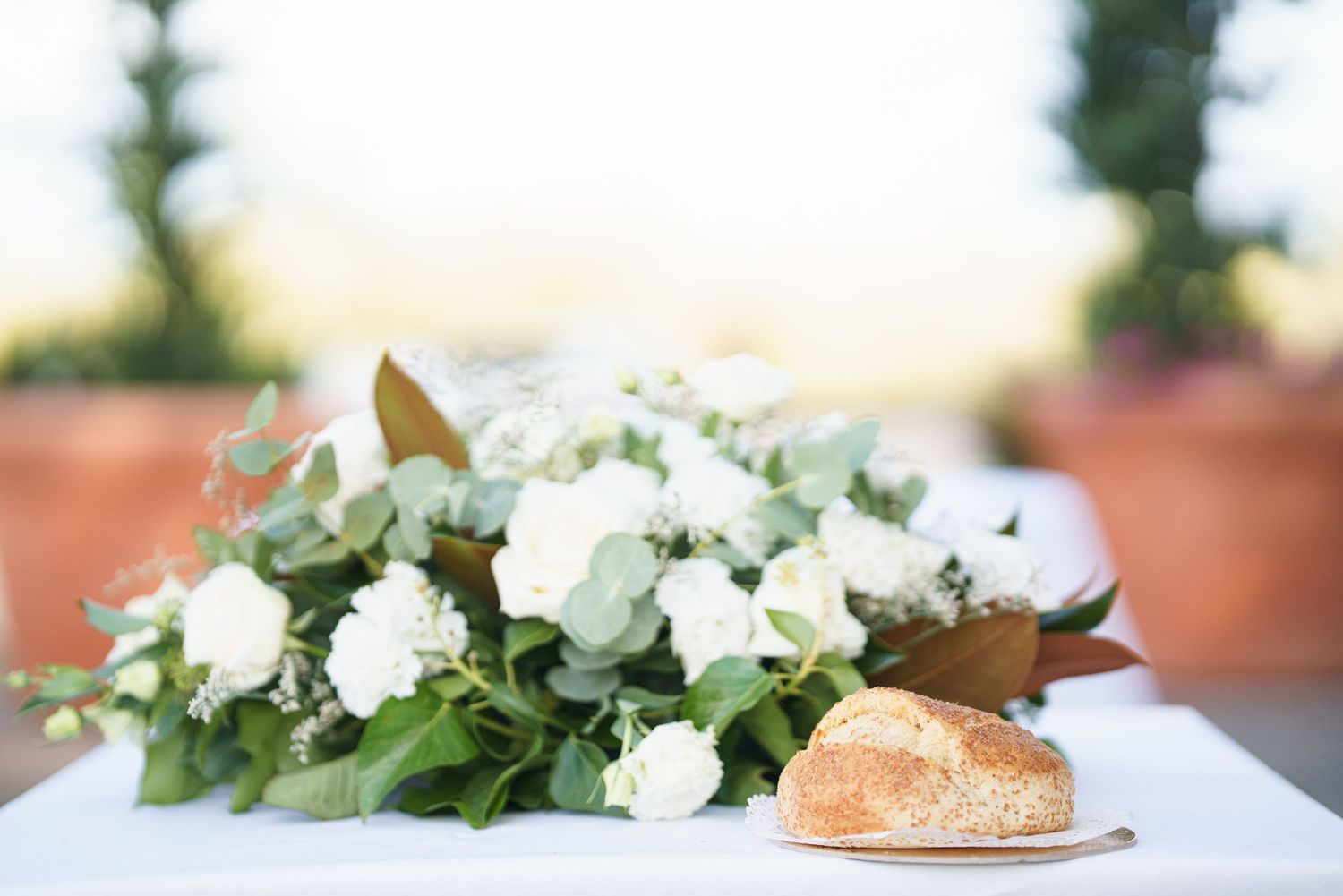 White floral arrangements with greenery displayed on a light surface.