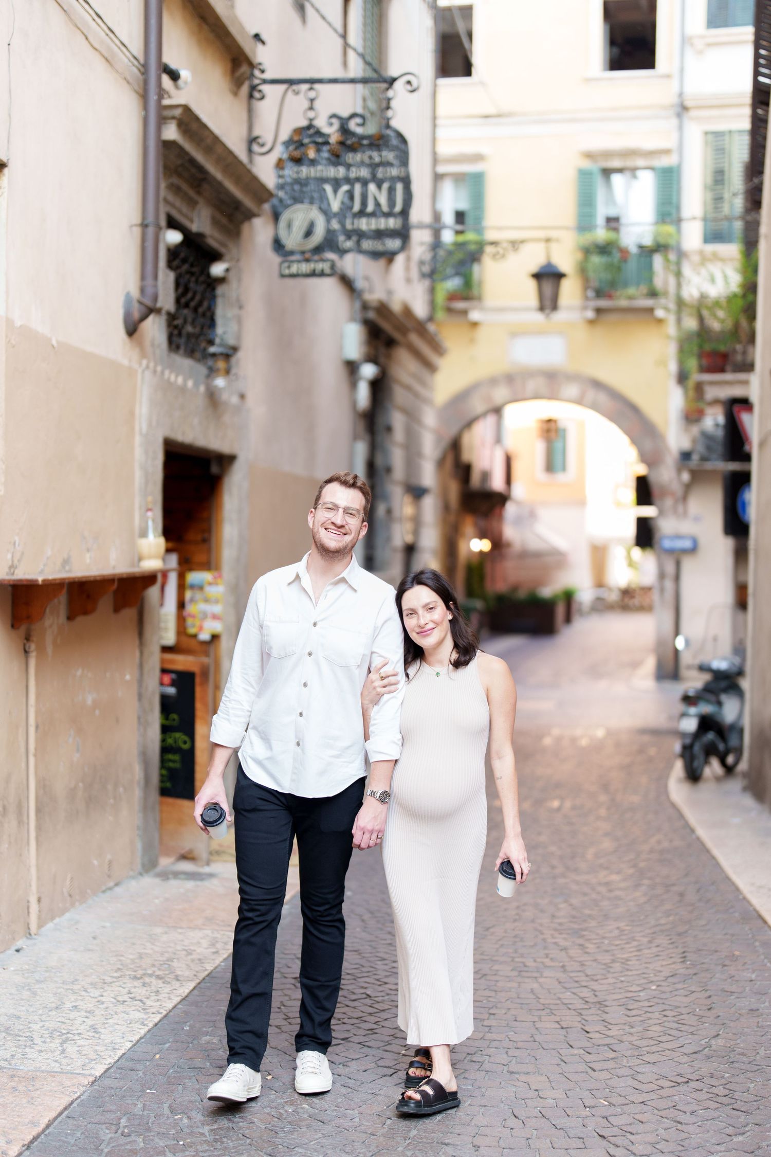 A couple walks hand in hand through charming cobblestone streets in a quaint European town.
