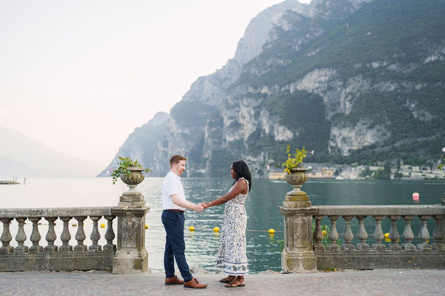 Couple walking together along the waterfront after their proposal in Riva del Garda