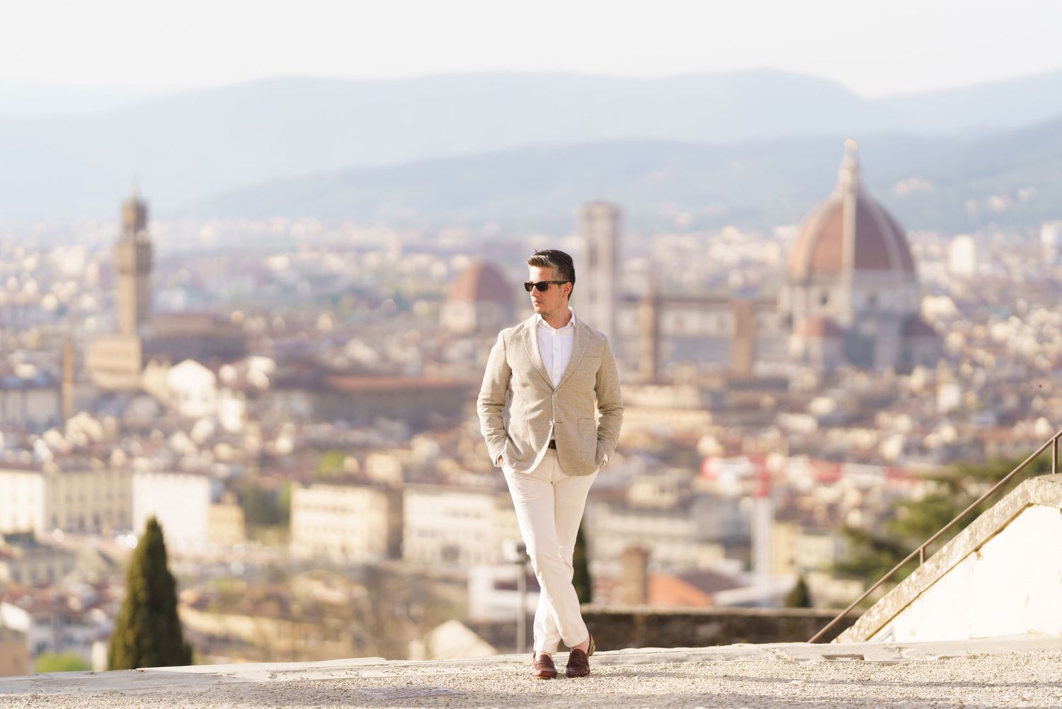 Panoramic view of Florence cityscape with historic architecture and rolling hills in golden afternoon light.
