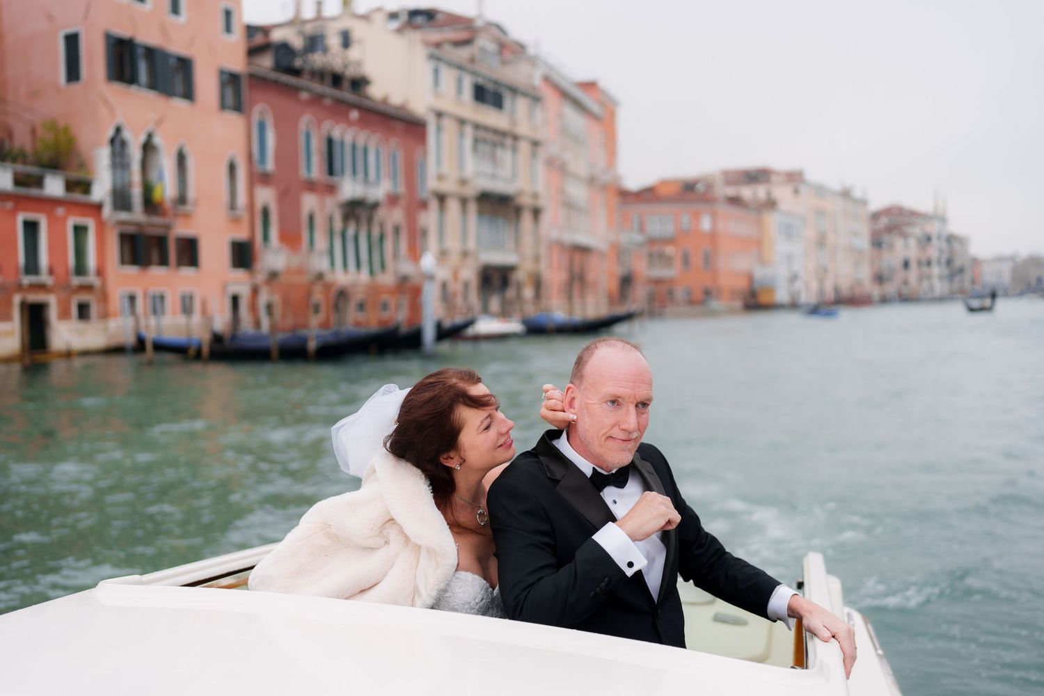 A romantic wedding couple shares intimate moments along Venice's scenic canals with historic buildings in the background.