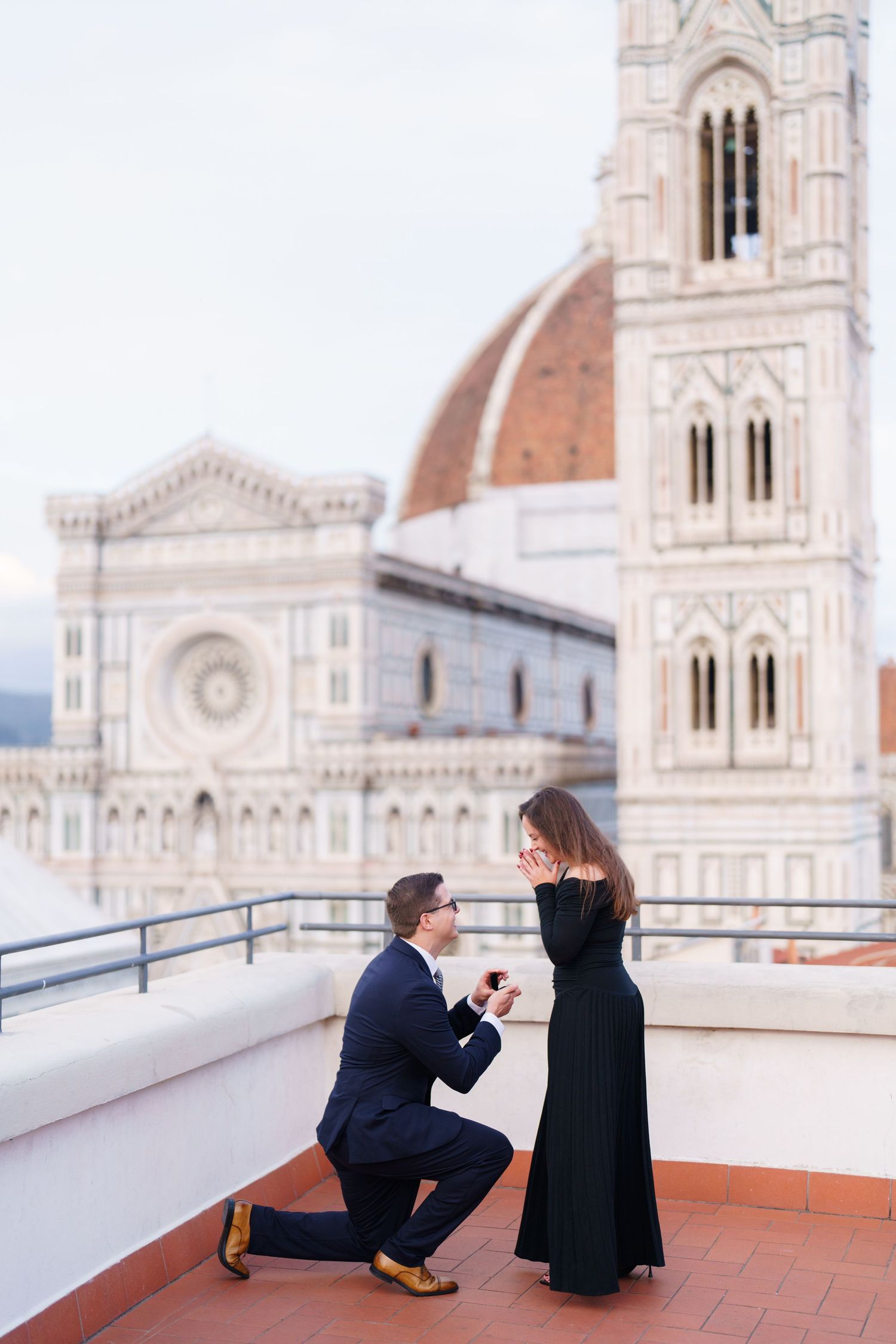 A romantic proposal moment on a rooftop terrace overlooking the historic Florence Cathedral and Duomo in Italy.