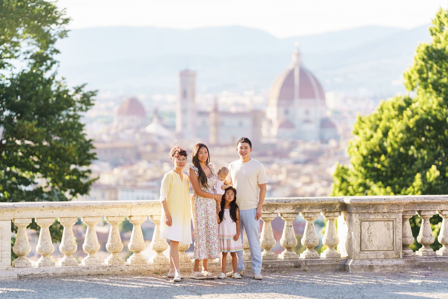 Family of five posing on a terrace in Florence, Italy, with the iconic Duomo cathedral visible in the background.