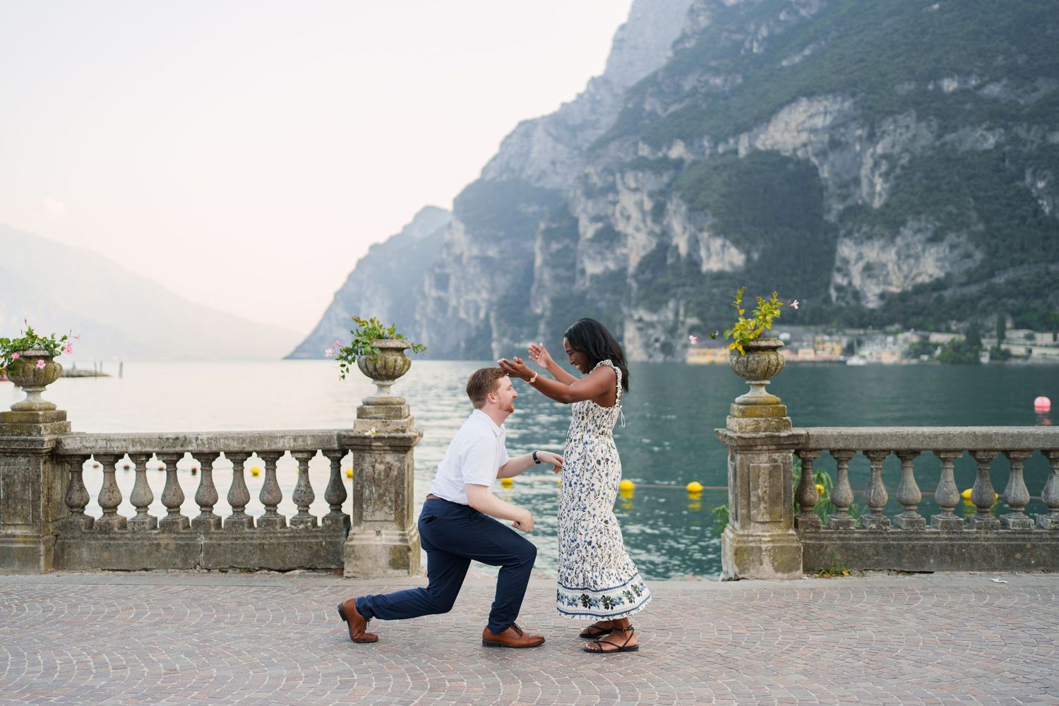 Engaged couple embracing beside Lake Garda during their Riva del Garda proposal session