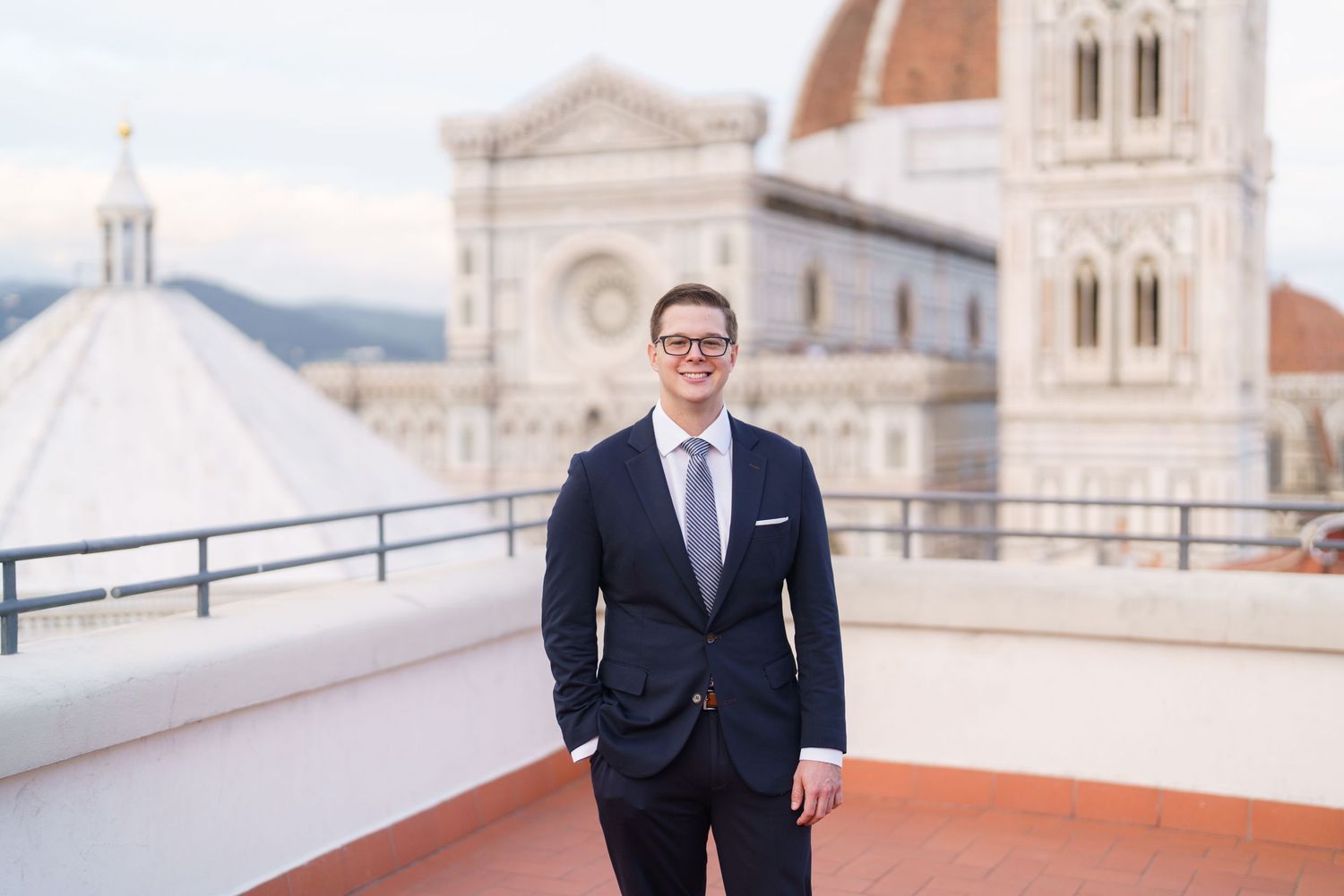 Professional portrait session at a historic building with cathedral architecture and ornate stone details in the background.