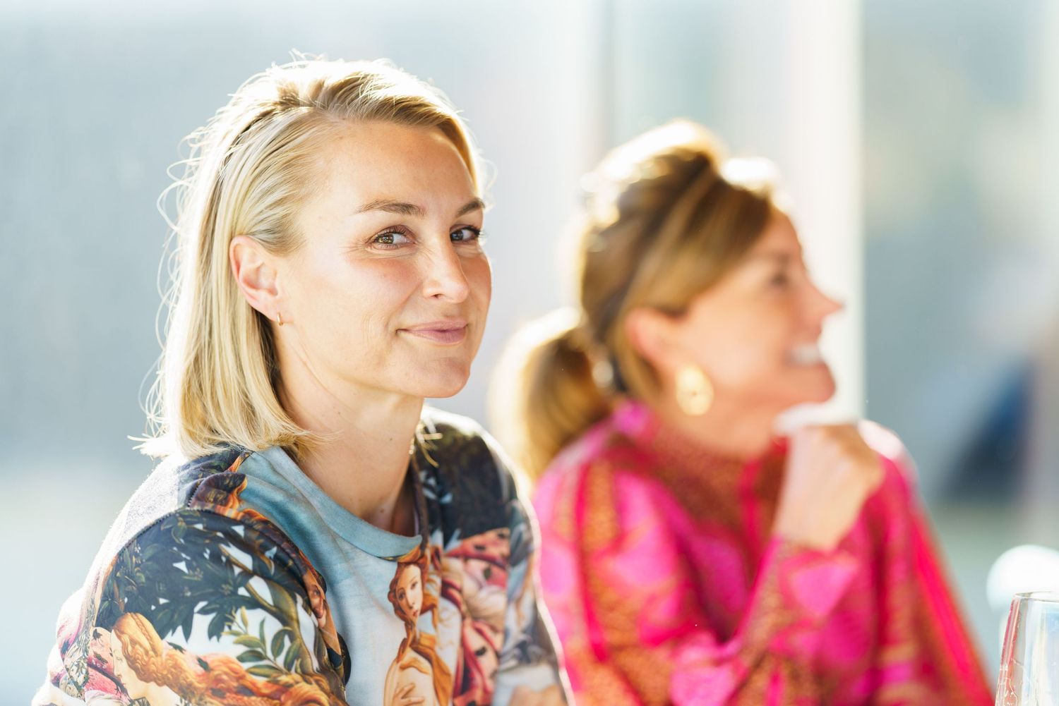 Two people enjoying conversation in bright natural lighting.