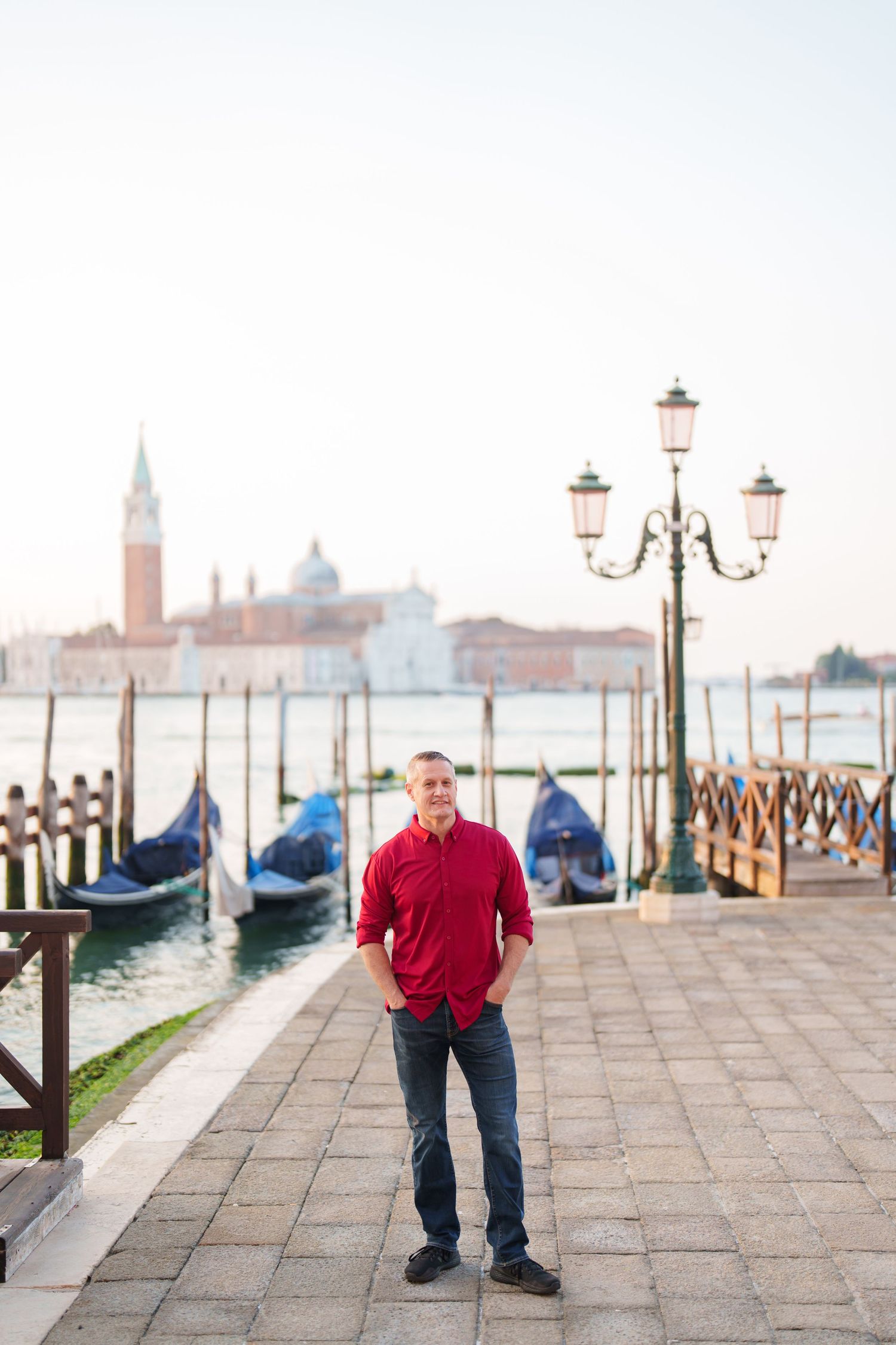 A series of four photos showing a waterfront promenade in Venice with ornate lampposts and the lagoon in the background.