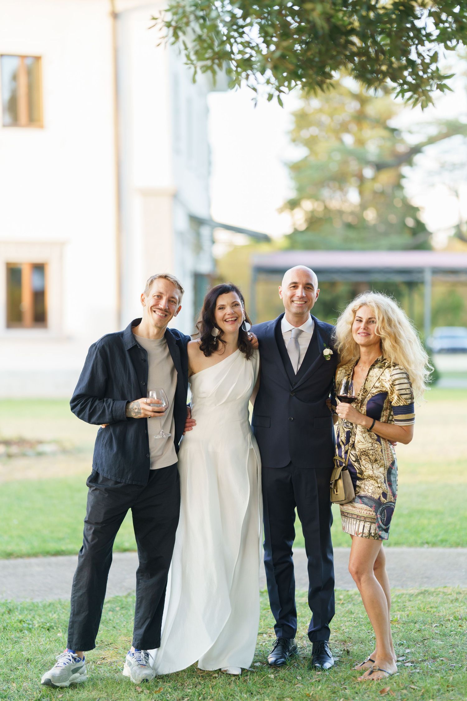 Wedding party members strike fun poses together outdoors.