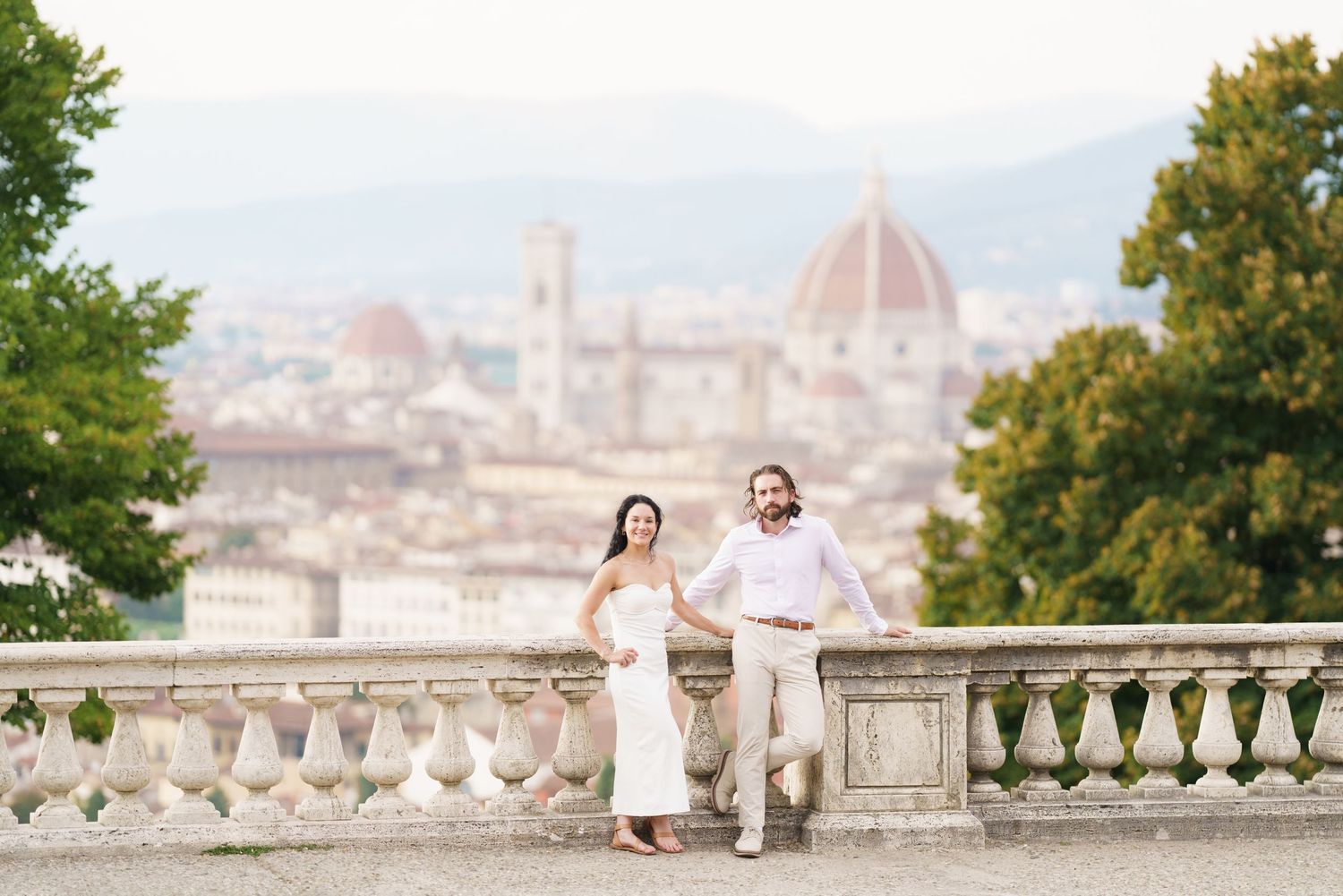 A romantic couple poses for wedding photos at Piazzale Michelangelo overlooking Florence's iconic Duomo cathedral.