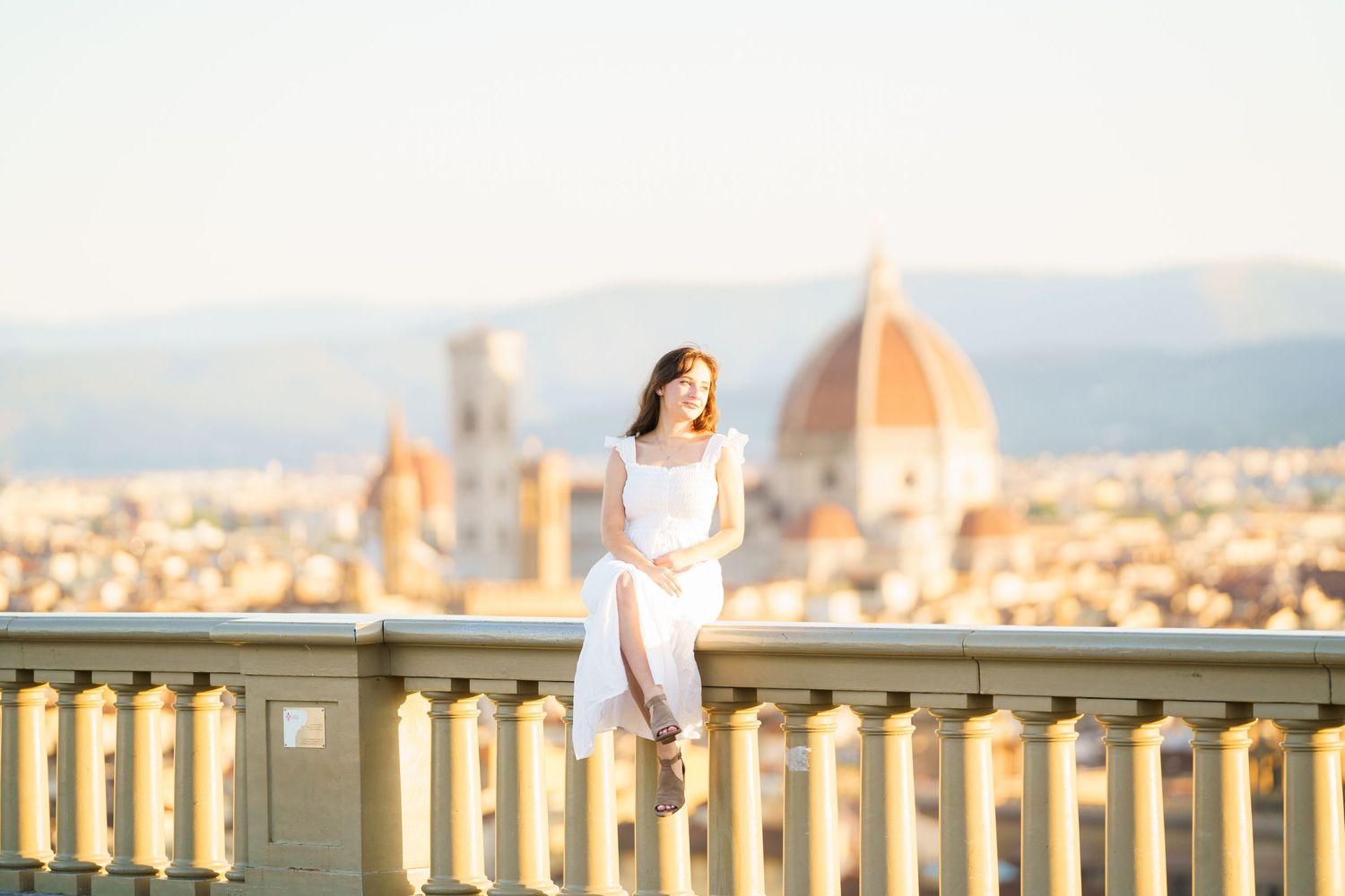 A scenic view of Florence, Italy at sunset with the iconic Duomo cathedral dome visible in the background.