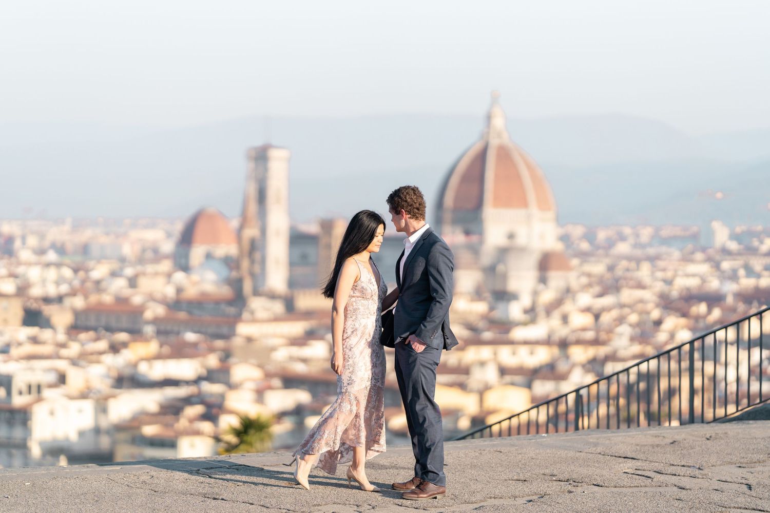 Romantic couple embraces while overlooking the stunning Florence cityscape with Duomo cathedral in the background.