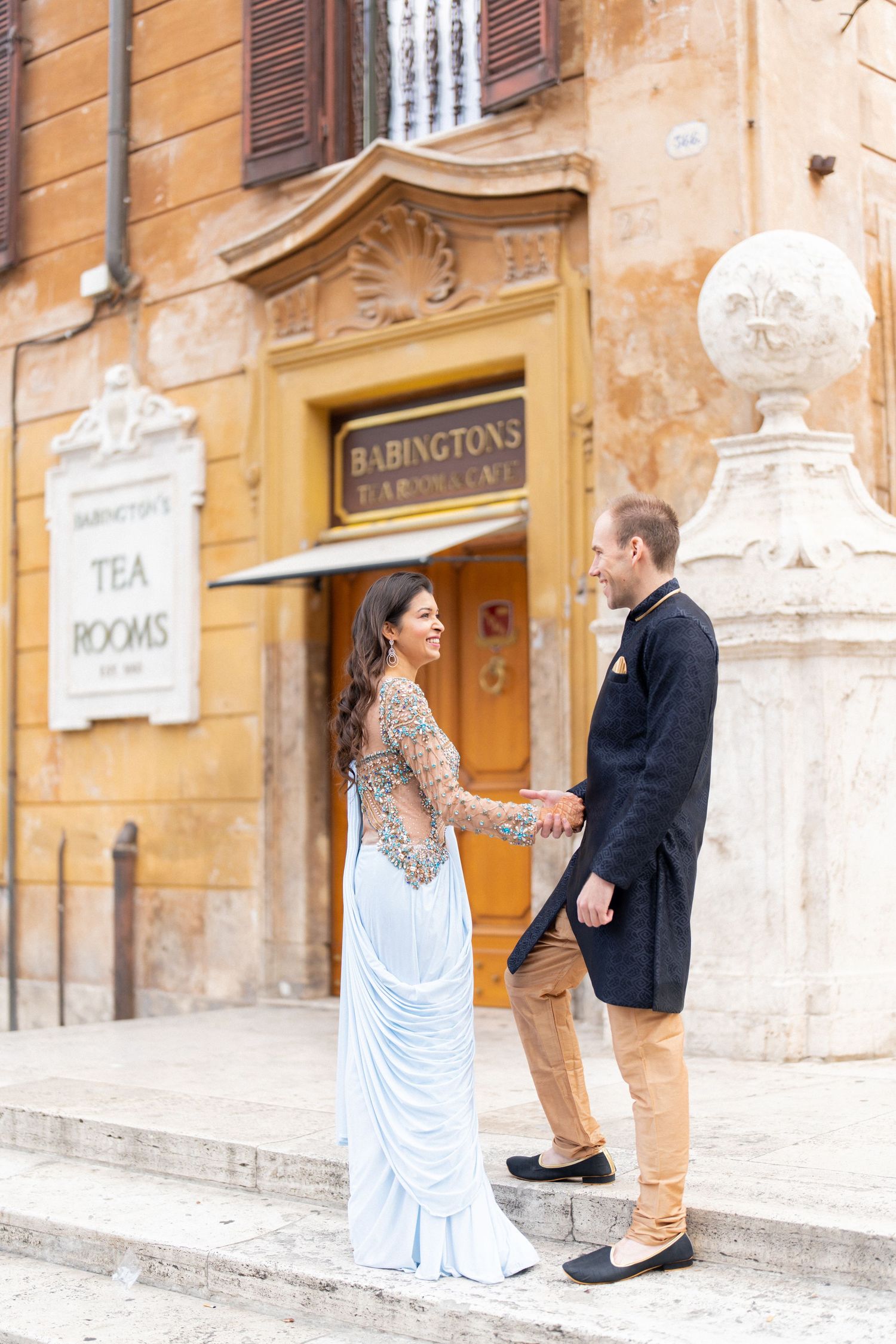 Romantic photoshoot outside Babington's Tea Room with historic architecture in background.