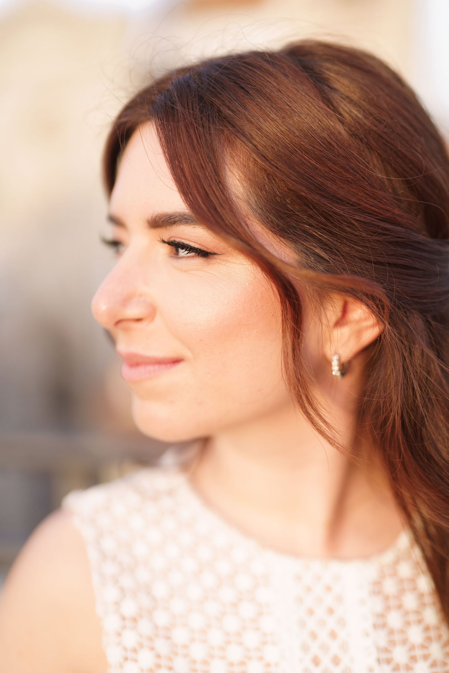 A woman in a white lace top smiles warmly while looking off to the side in a series of soft-focus portraits.