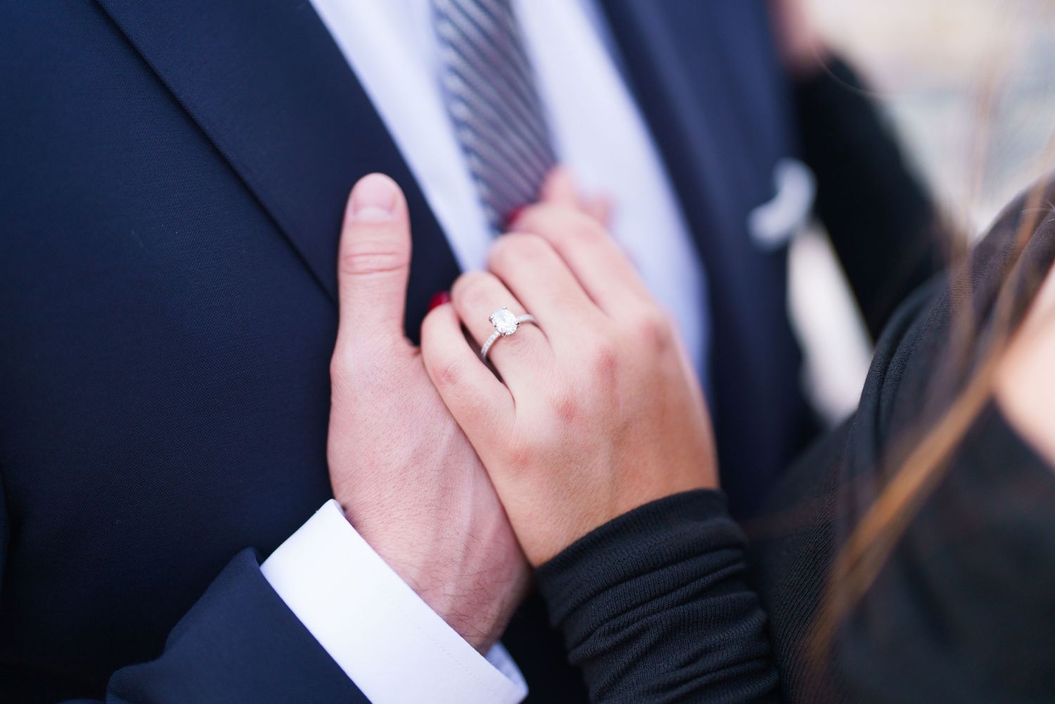 A close-up view of hands exchanging wedding rings during a marriage ceremony.