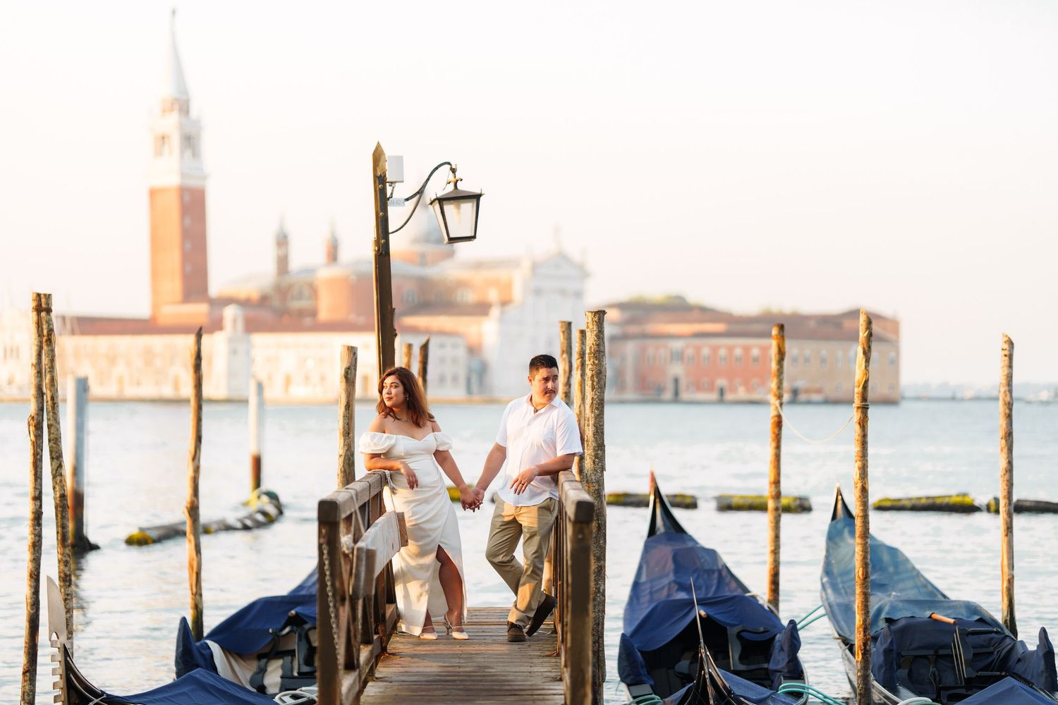 photographer veniceGondolas moored along wooden posts in Venice with the iconic San Giorgio Maggiore church visible across the lagoon.