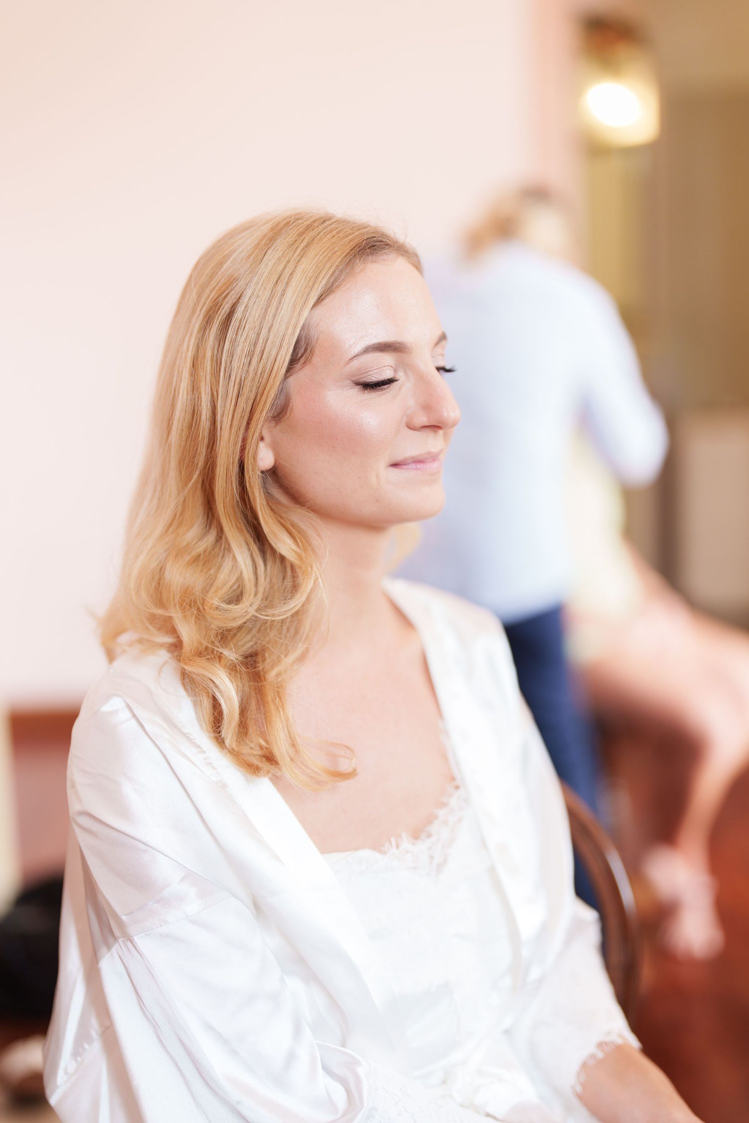A serene moment of wedding preparation in a white silk robe.