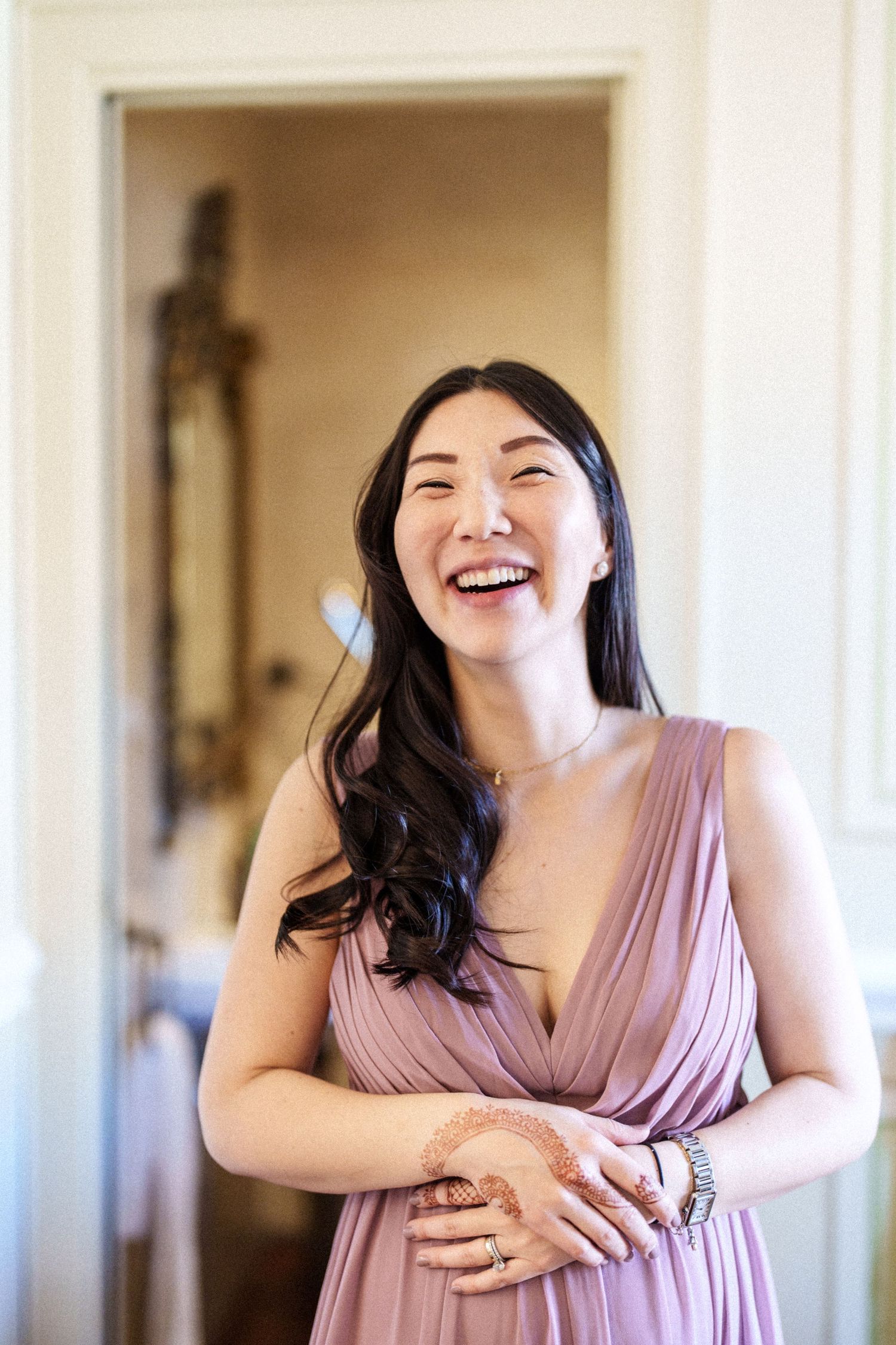 Three candid shots show joyful moments in a pink dress against white walls.