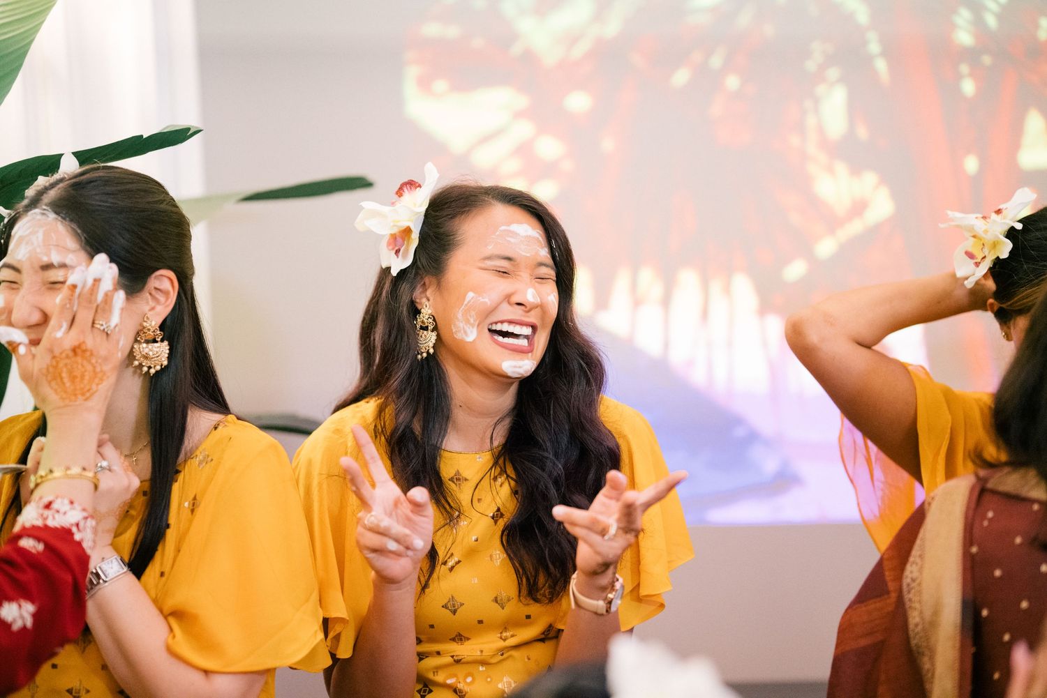 Guests in yellow and bright attire dancing and celebrating at a festive event.