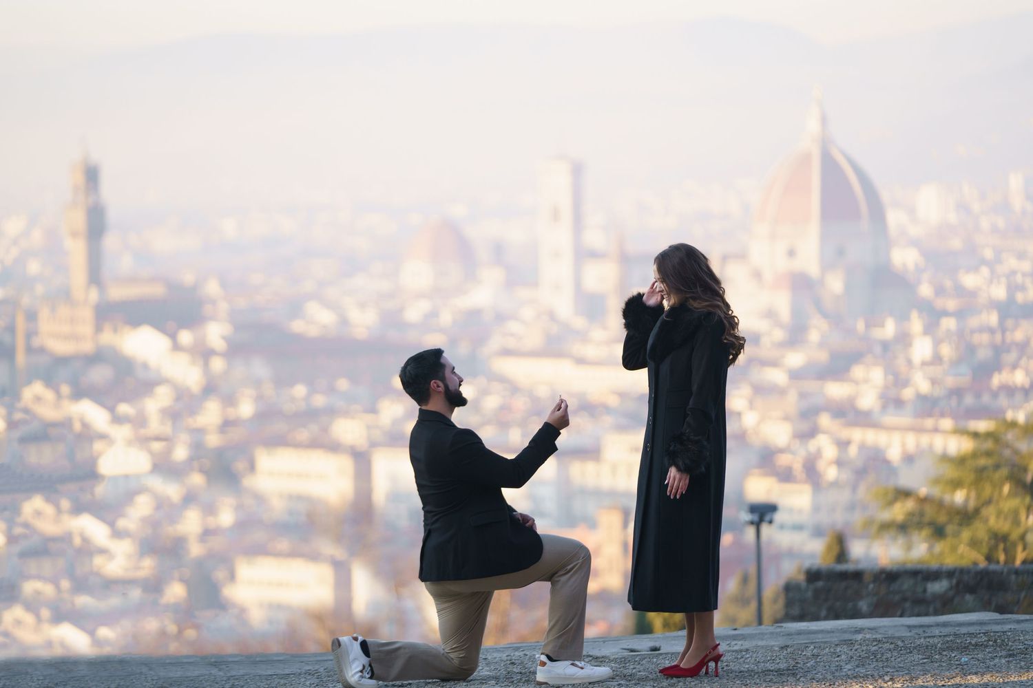A romantic proposal silhouette against the scenic backdrop of Florence, Italy with the Duomo cathedral visible in the distance.