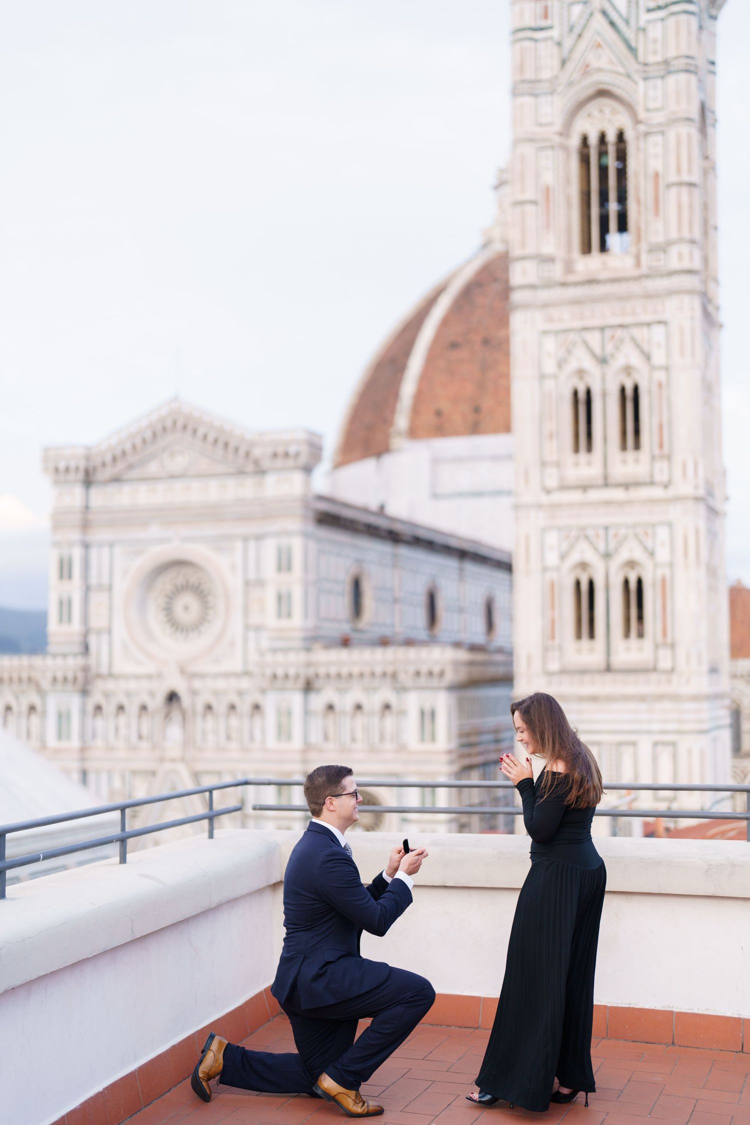 A romantic proposal moment on a rooftop terrace overlooking the Florence Cathedral and Duomo in Italy.