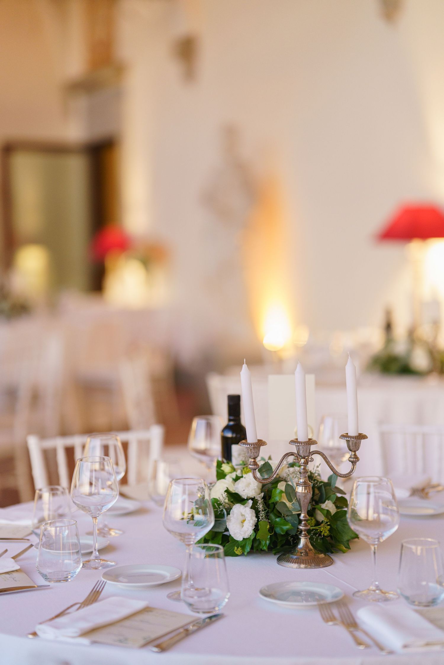 White tablescapes with delicate floral centerpieces and glassware in an elegant dining setting.