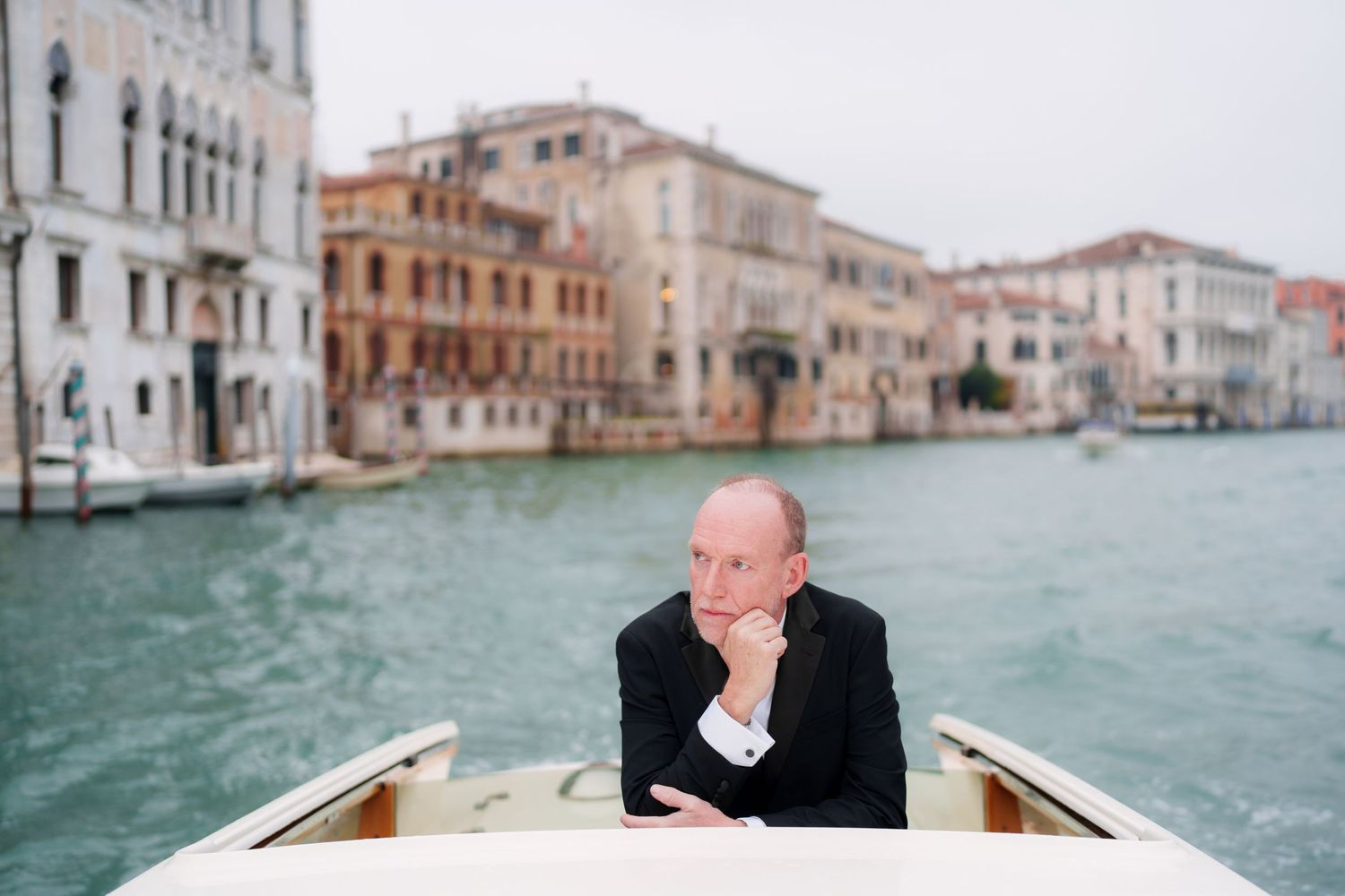 A series of photos showing a boat ride through the turquoise canals of Venice between historic buildings.