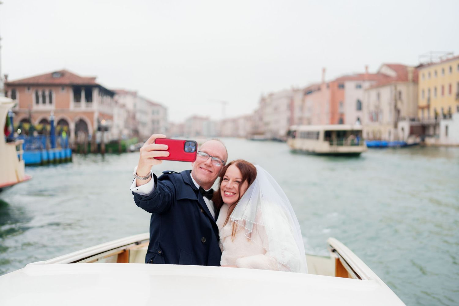 A romantic couple rides in a traditional wooden gondola through the scenic canals of Venice, Italy.