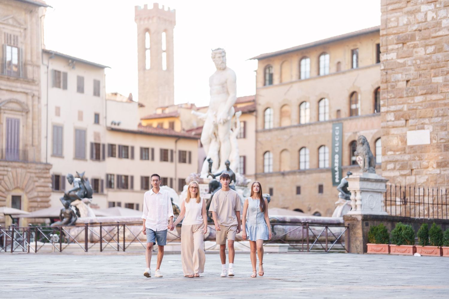 photographer Florence  series of connected photos showing tourists walking through a historic Italian plaza with stone buildings and towers.