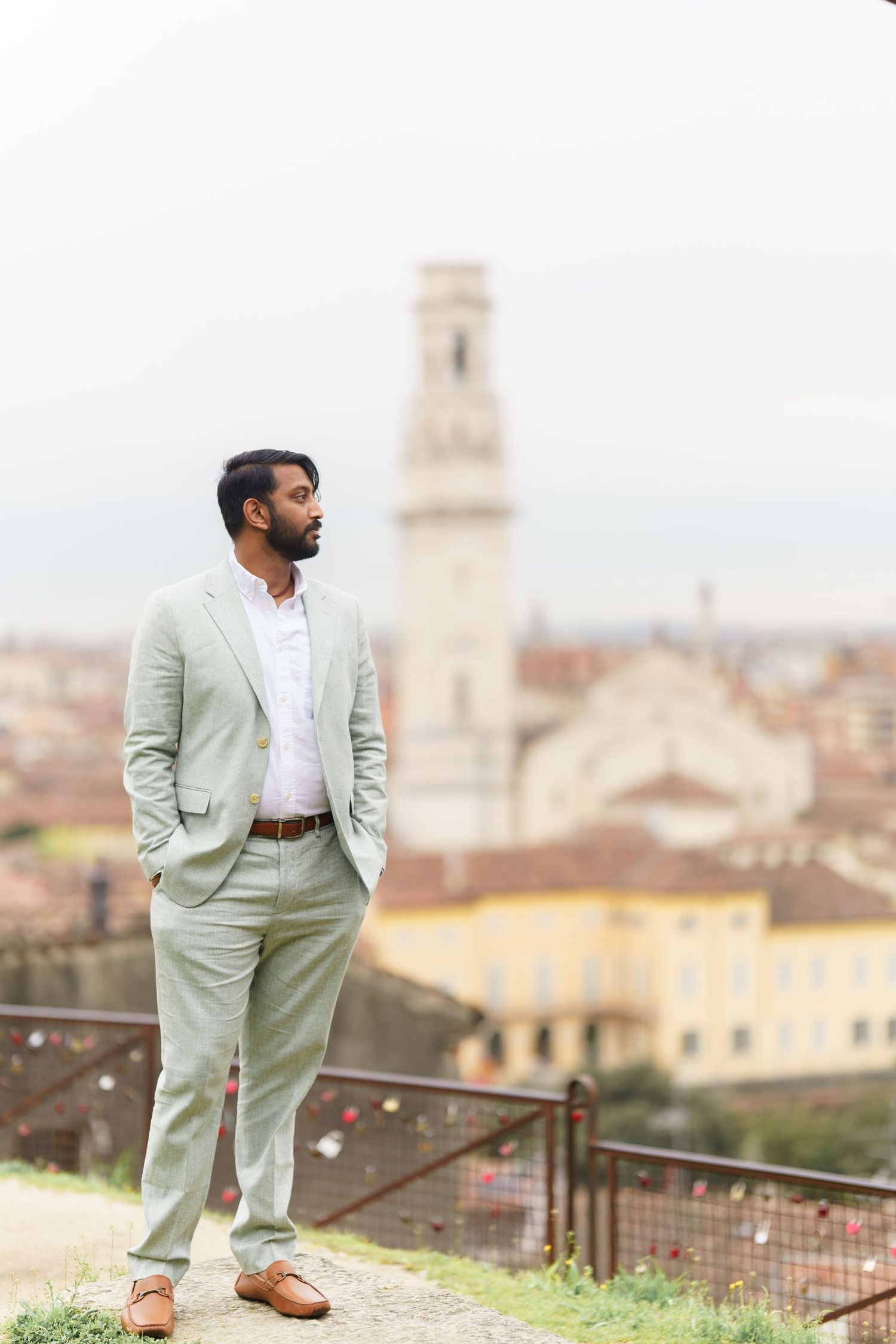 A person in a light mint green suit and white shirt poses against an Italian cityscape backdrop in multiple angles.