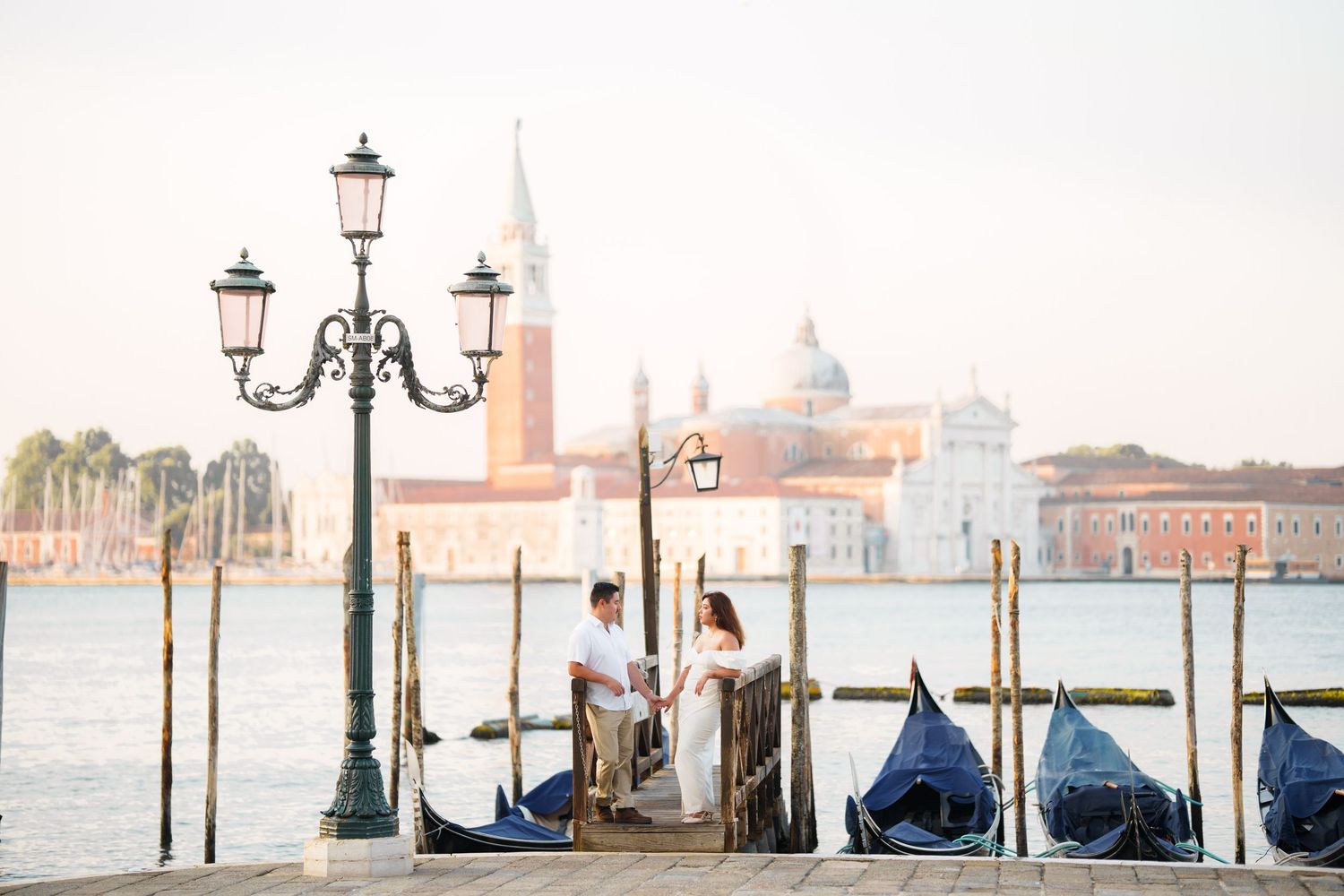 Romantic scene in Venice with moored gondolas and San Giorgio Maggiore church in the soft morning light.