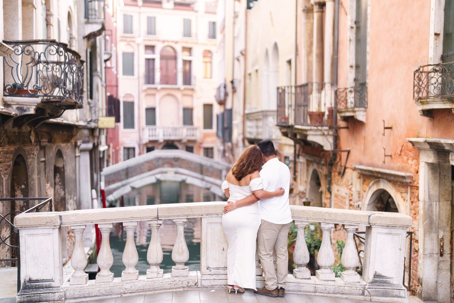 White laundry hanging on clotheslines between old buildings along a narrow canal in Venice, Italy.