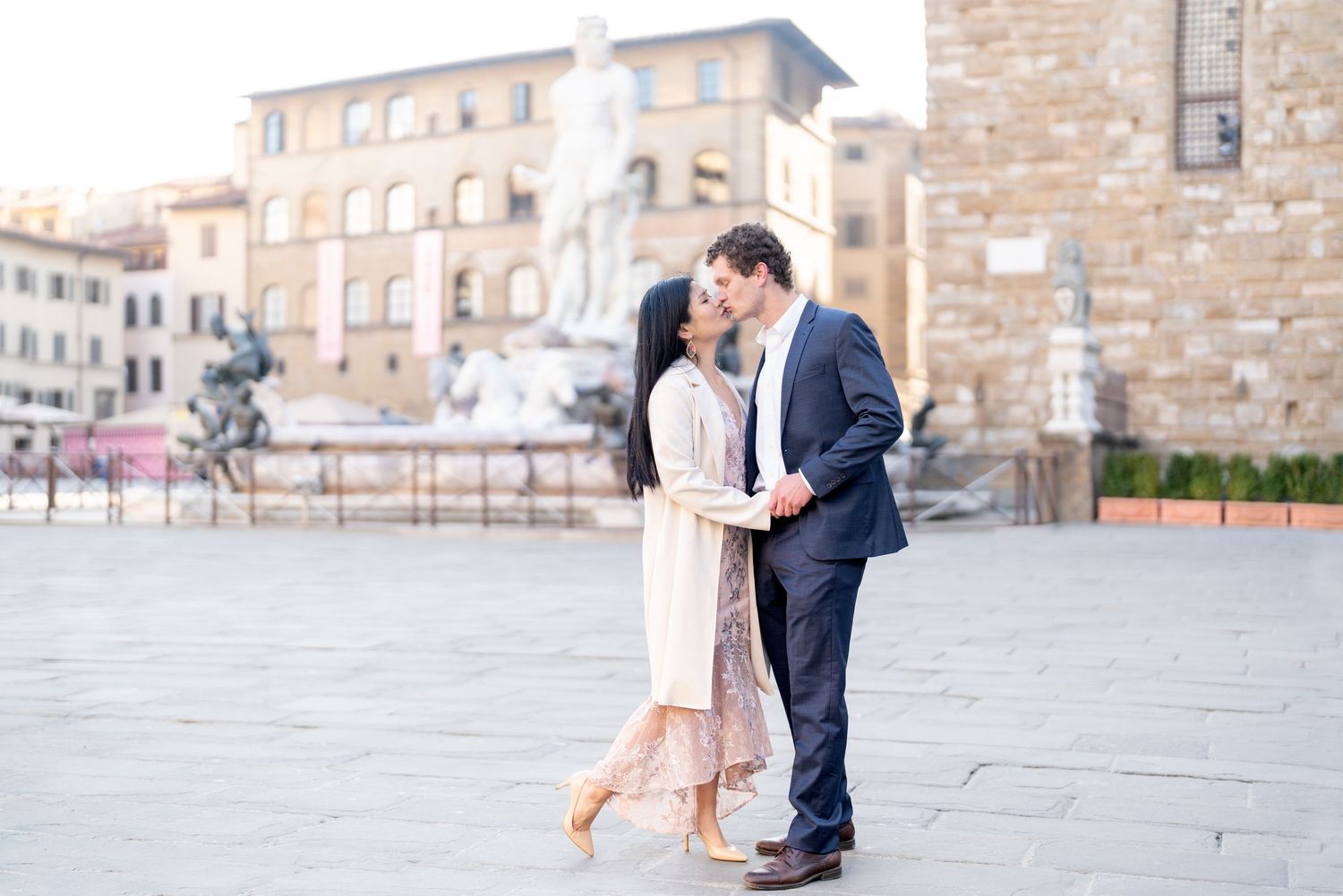 A romantic couple shares an intimate moment in front of historic Italian architecture in Florence.