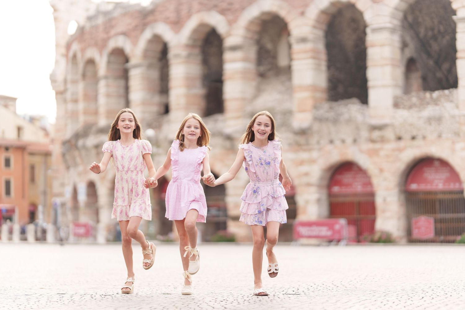 Verona family photographer family walking in front of Verona Arena Italy
