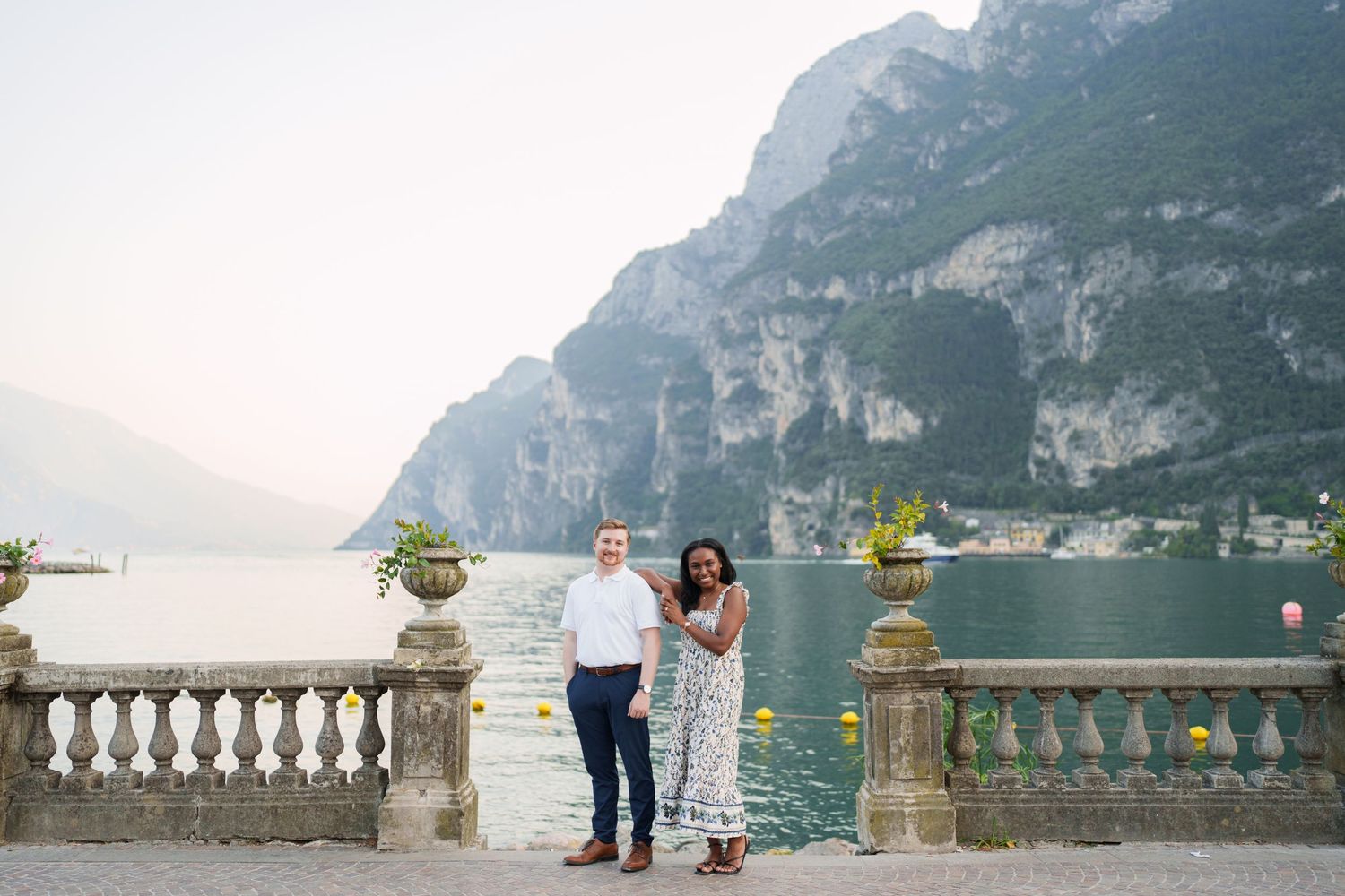 Engaged couple embracing beside Lake Garda during their Riva del Garda proposal session