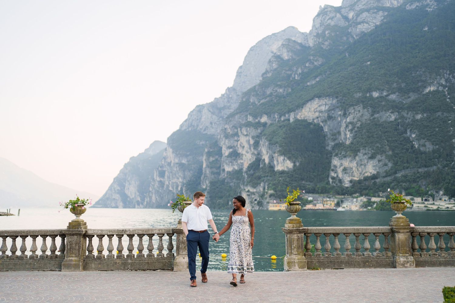 Engaged couple embracing beside Lake Garda during their Riva del Garda proposal session