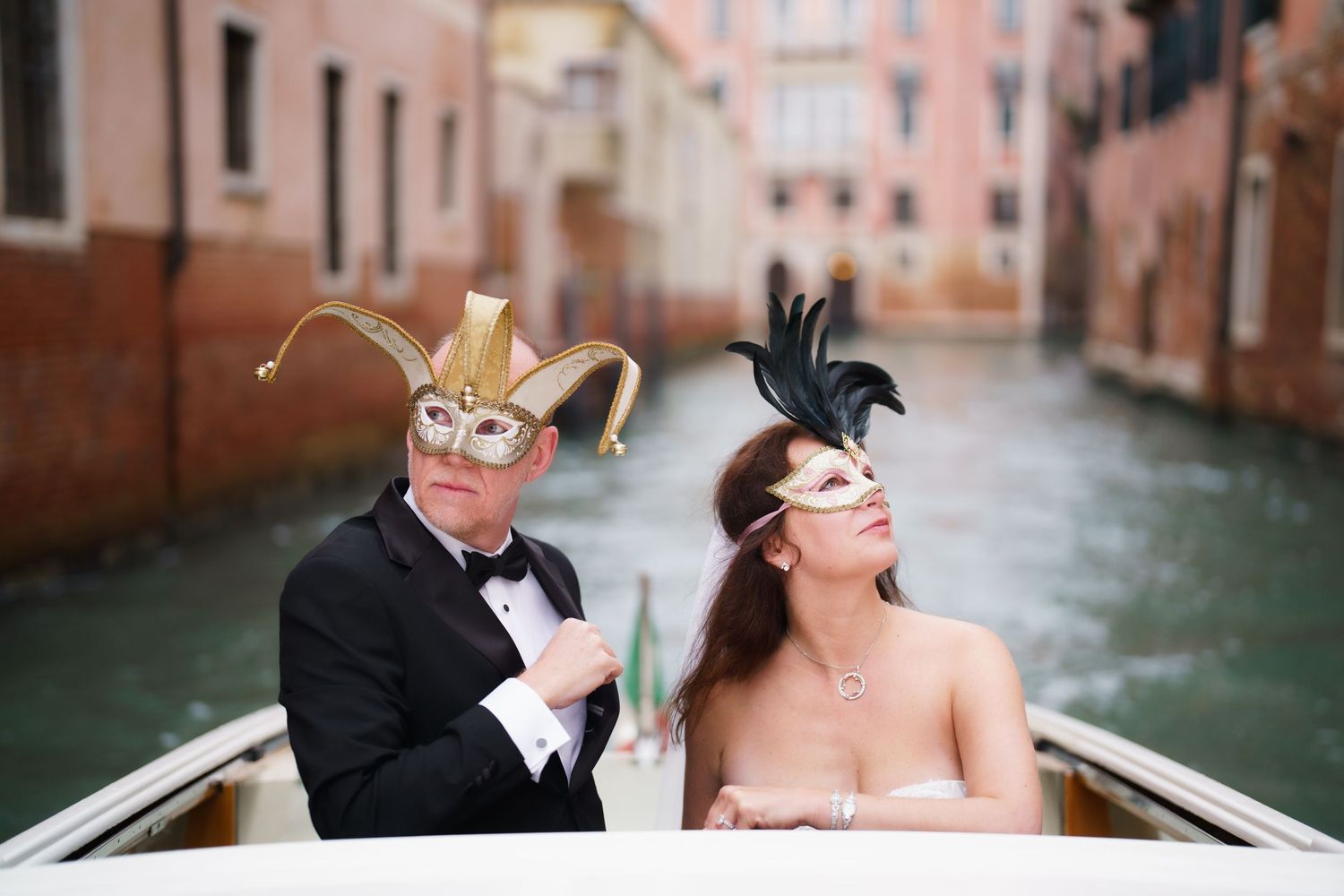Romantic couple sharing a tender moment while riding in a gondola through the scenic canals of Venice, Italy.