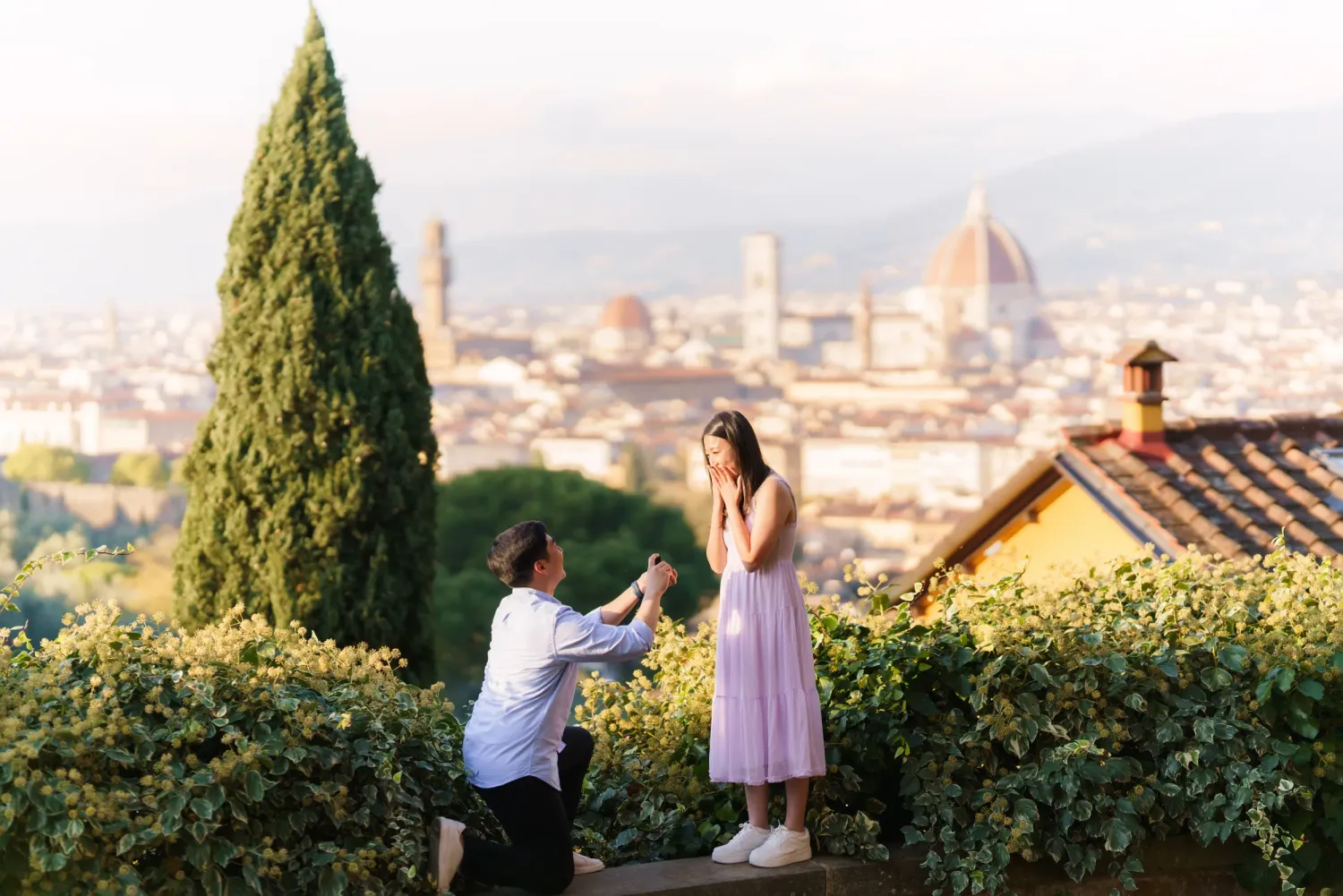 People enjoying a scenic overlook of Florence, Italy with cypress trees and historic architecture in the background.