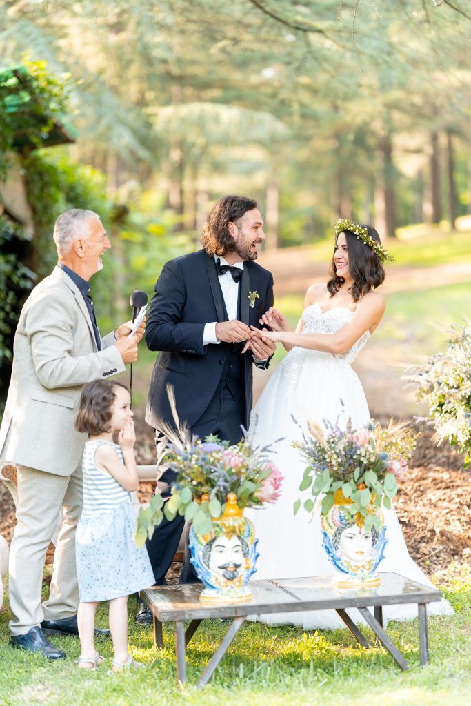 Wedding party enjoying candid moments around decorated table in garden setting.