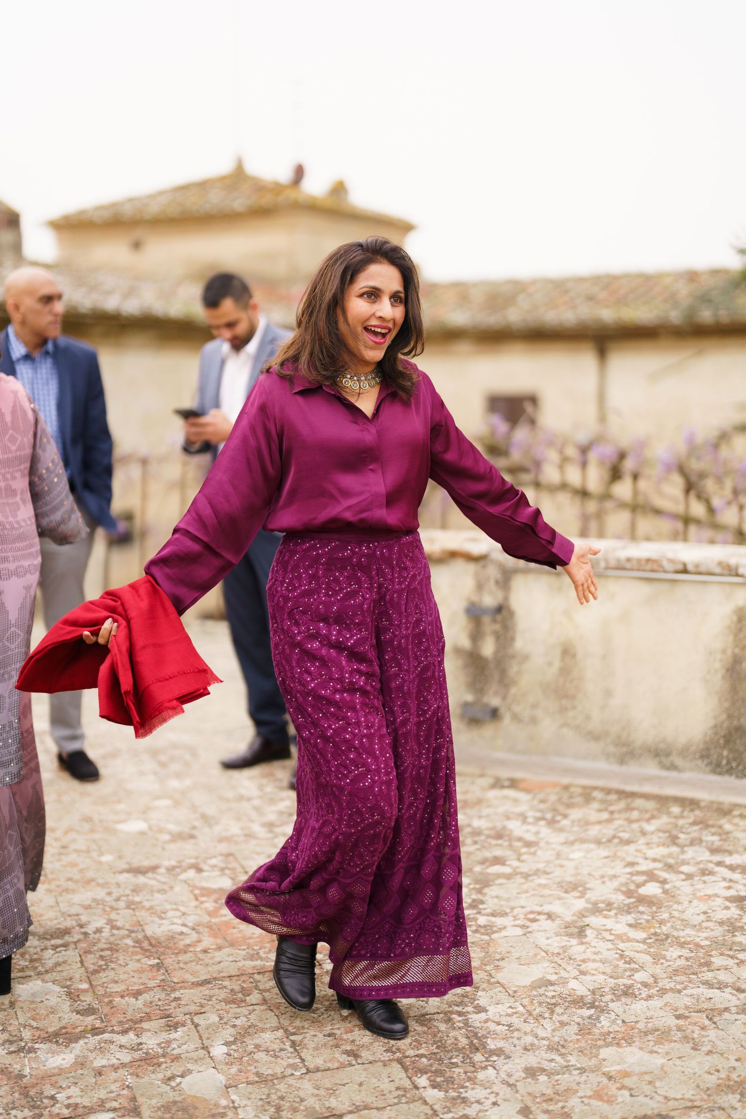 Woman in a purple dress twirling and dancing on a stone courtyard.