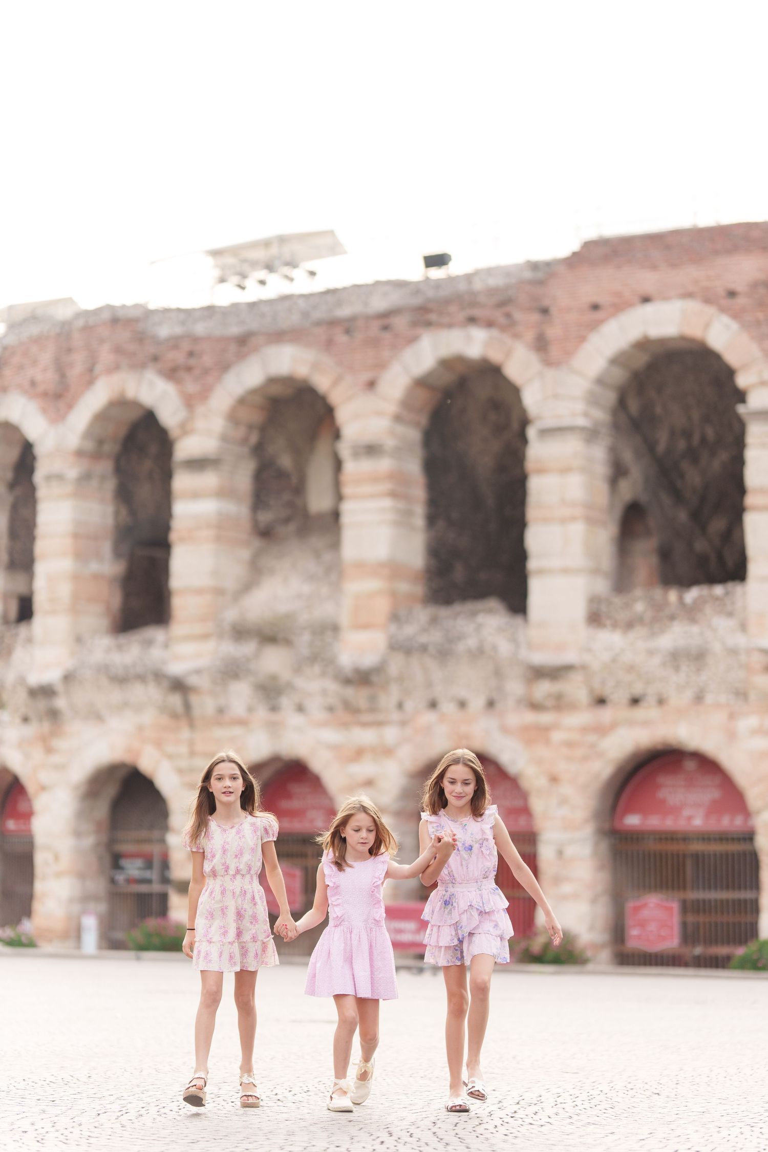 Verona family photographer family walking in front of Verona Arena Italy