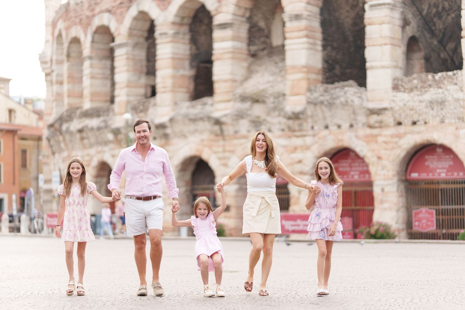 Verona family photographer family walking in front of Verona Arena Italy